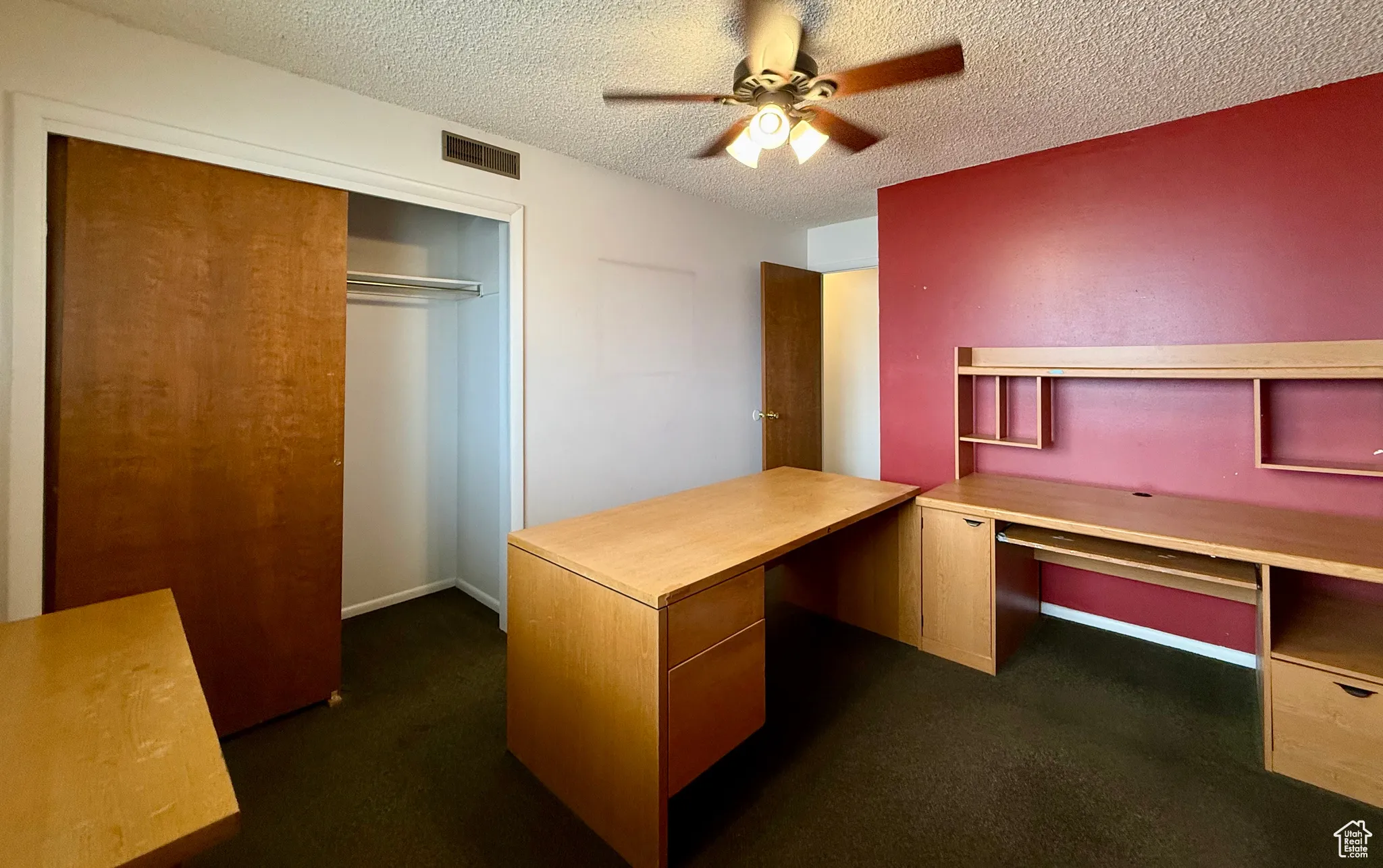 Unfurnished office featuring a textured ceiling and a ceiling fan