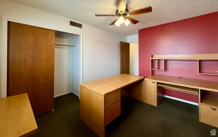 Unfurnished office featuring a textured ceiling and a ceiling fan