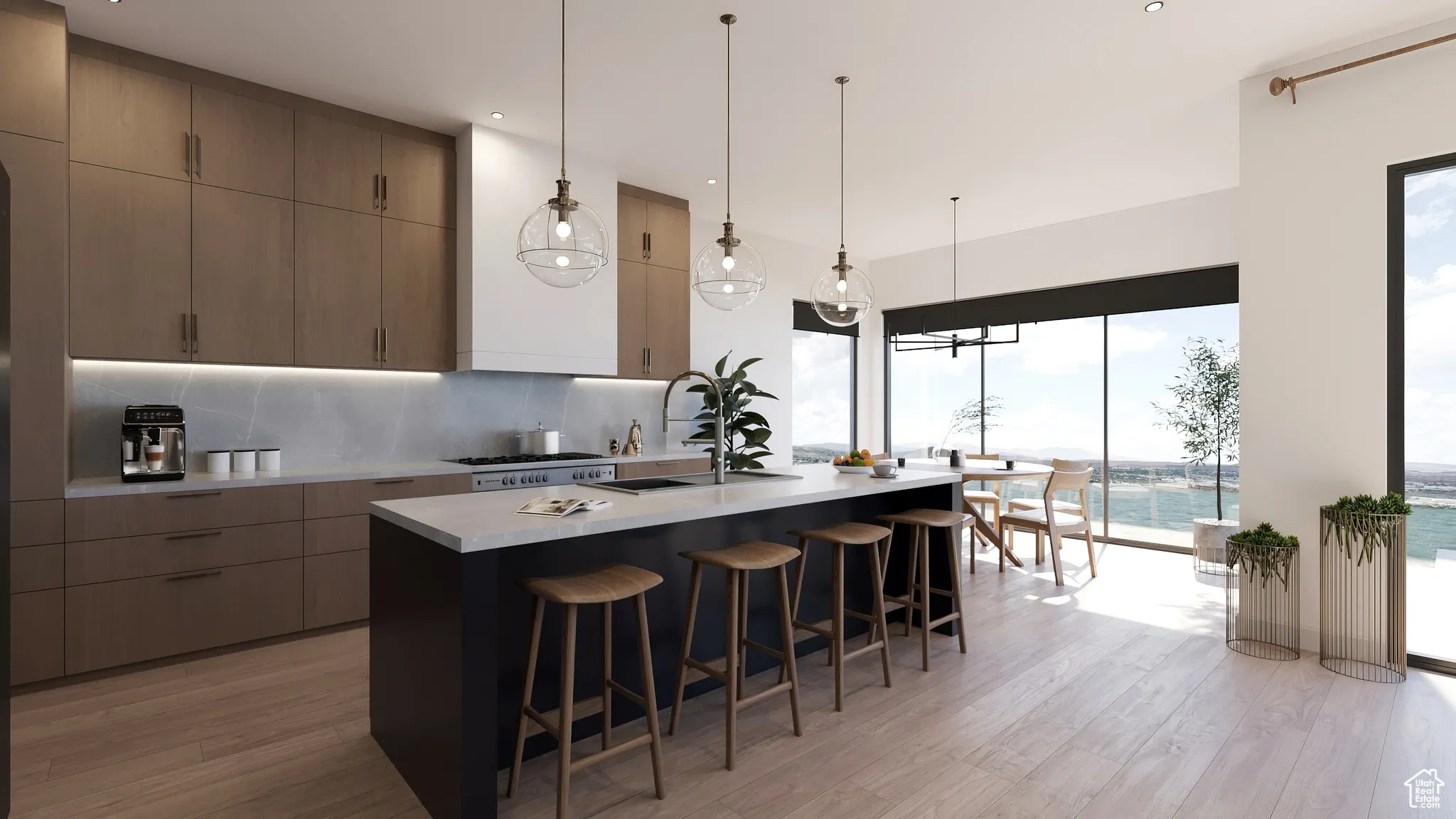 Kitchen with modern cabinets, backsplash, light countertops, a center island with sink, and a breakfast bar area