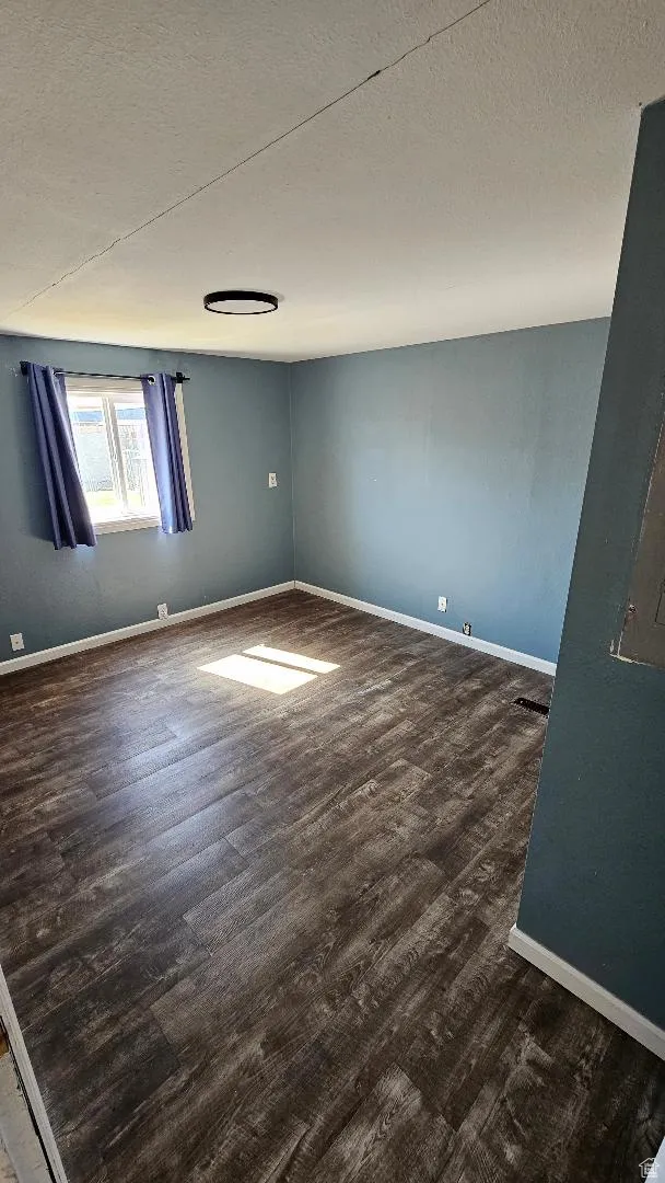 Spare room featuring a textured ceiling and wood finished floors