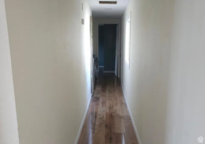 Hall with hardwood / wood-style flooring and baseboards
