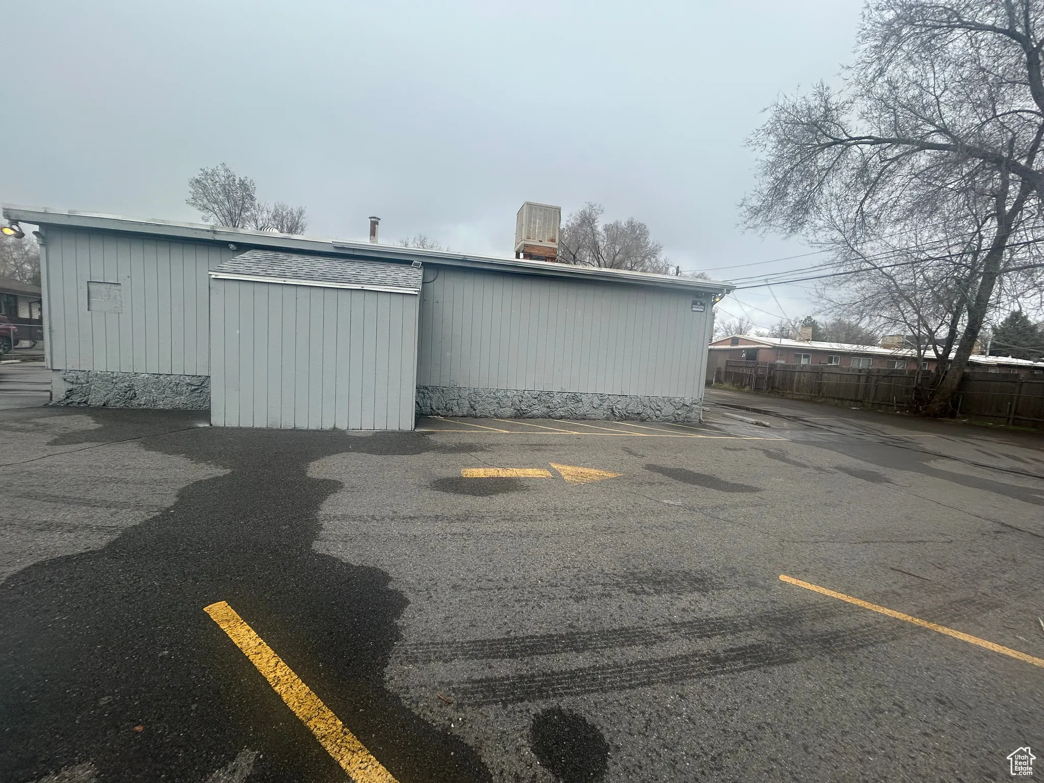 Uncovered parking lot featuring an outbuilding