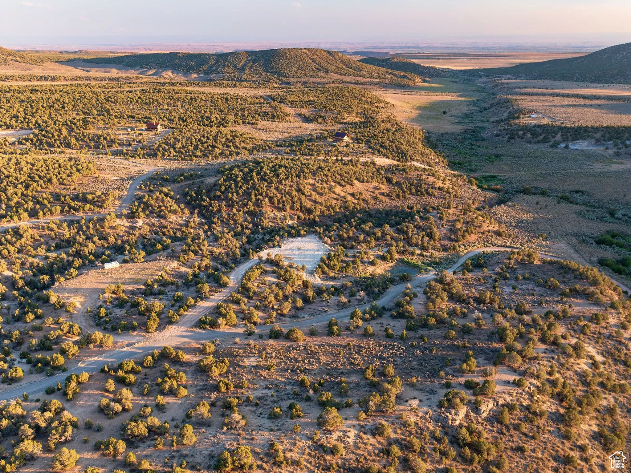 Aerial view of property and surrounding area featuring a mountain backdrop and rural landscape