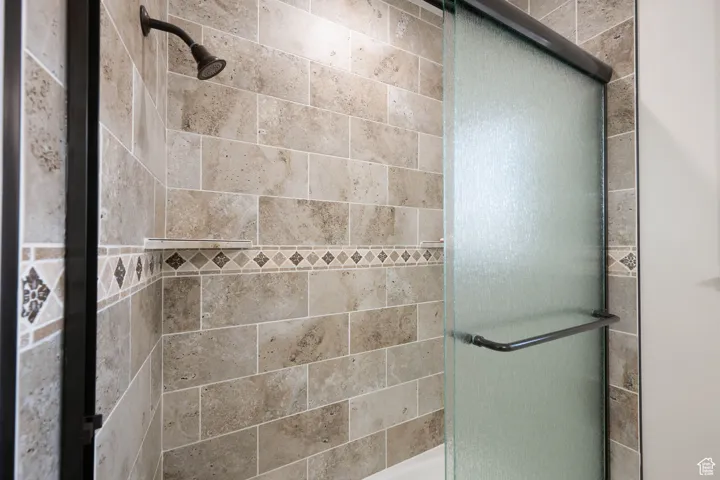 ADU bathroom with a tile shower and glass sliding shower door