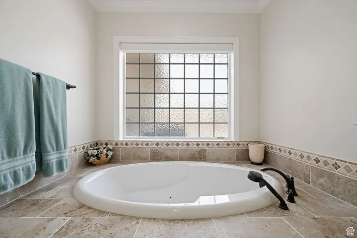 Full master suite bath with a jetted garden tub, acrylic glass block window with an electric shade.