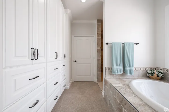 Full master suite bath featuring a jetted garden, ornamental molding and lots of storage with soft-close cabinetry.