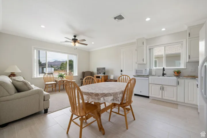 ADU Dining space with ornamental molding, ceiling fan, and recessed lighting, full kitchen with convection oven, microwave, farm sink, dishwasher, tile / carpet flooring.
