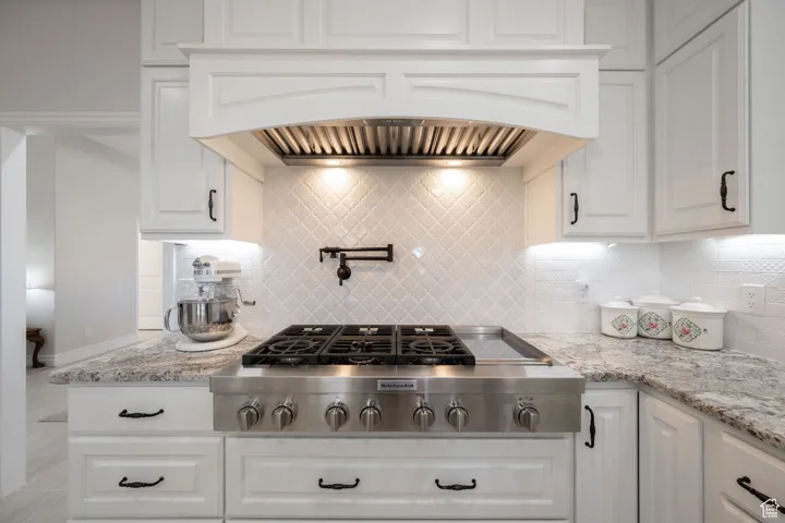 Main Kitchen featuring tile backsplash, stainless steel gas 48" cook-top, custom exhaust hood, and white soft-close cabinets