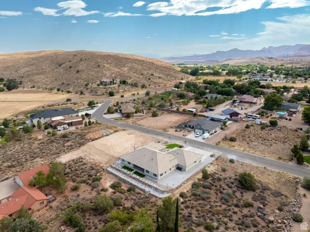 Aerial view of residential area featuring a desert landscape and a mountain backdrop