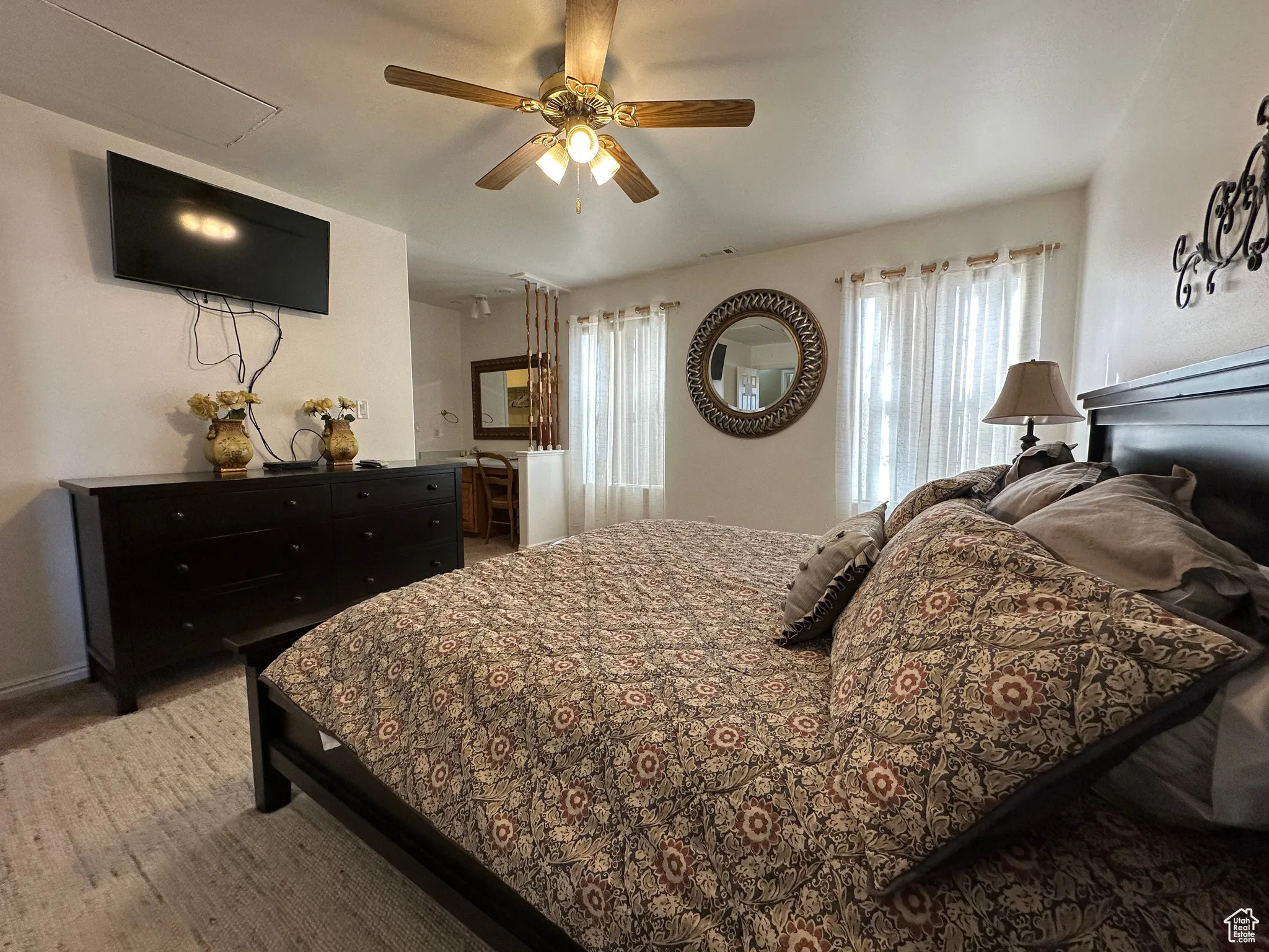 Carpeted bedroom with a ceiling fan