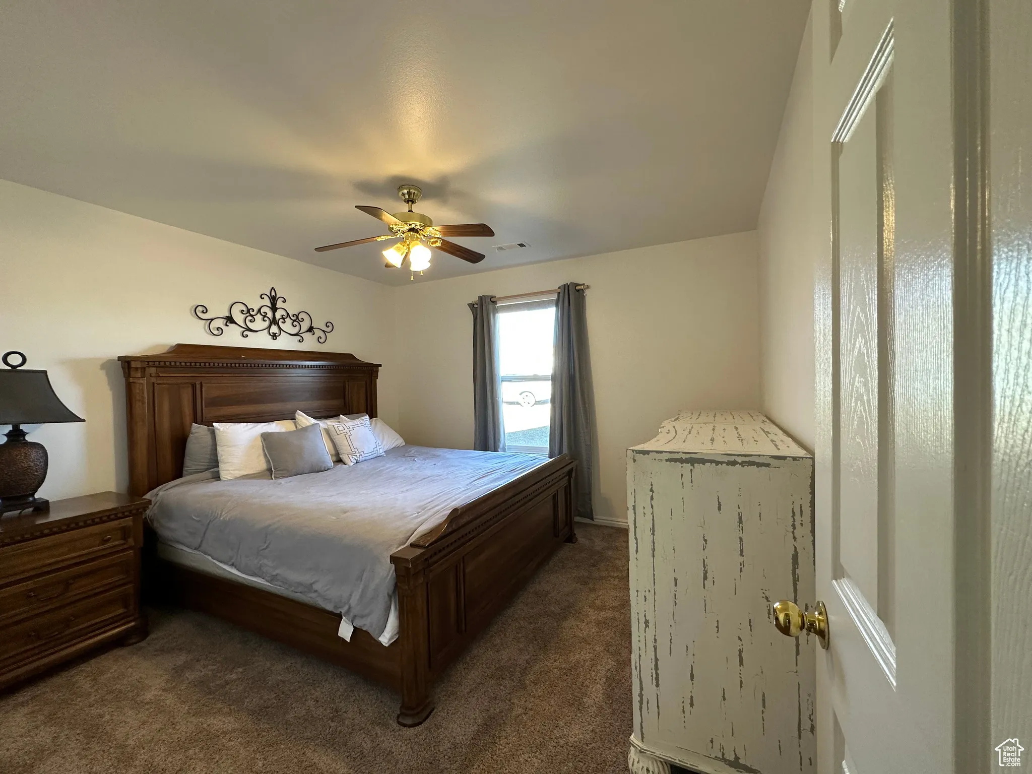 Carpeted bedroom with ceiling fan