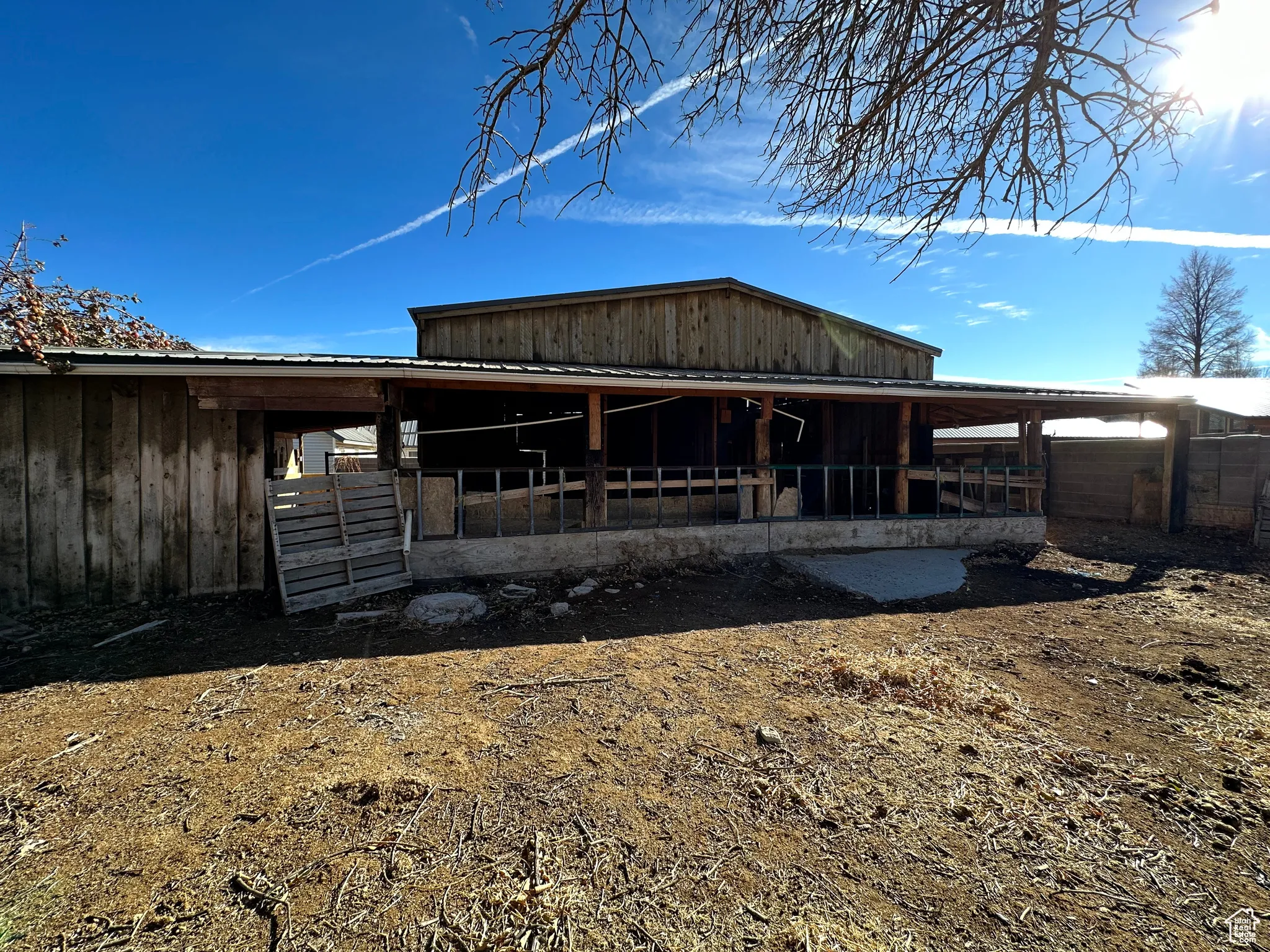 Rear view of house with an exterior structure, a metal roof, and an outdoor structure