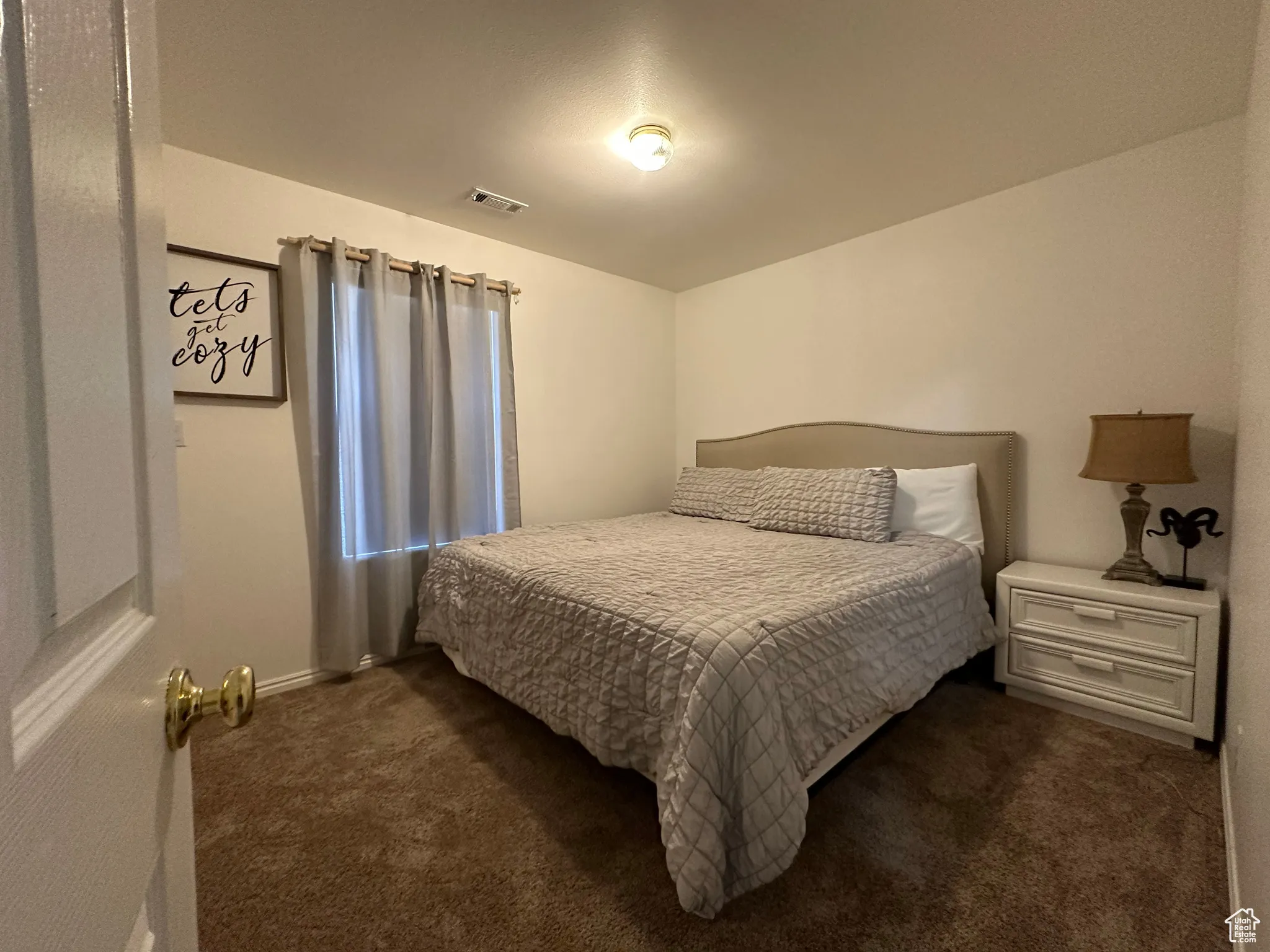 Bedroom featuring dark carpet and baseboards