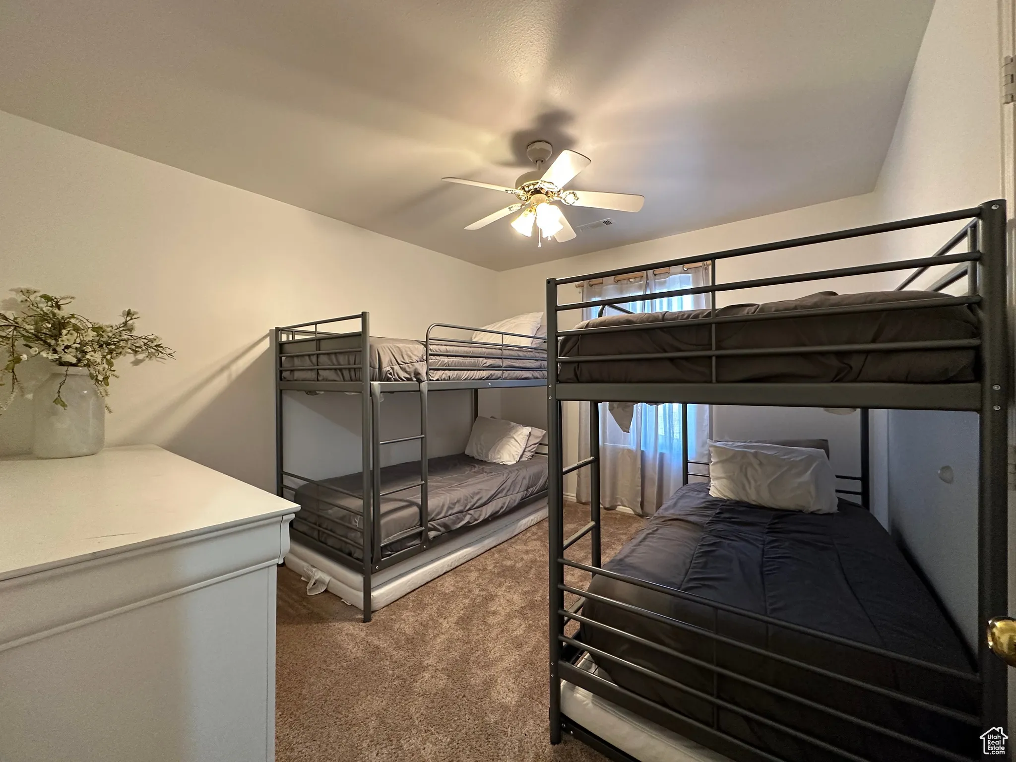 Carpeted bedroom featuring a ceiling fan