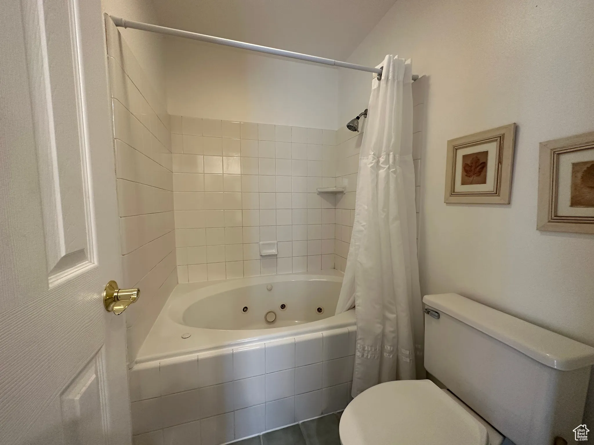 Bathroom featuring toilet and a combined bath / shower with jetted tub