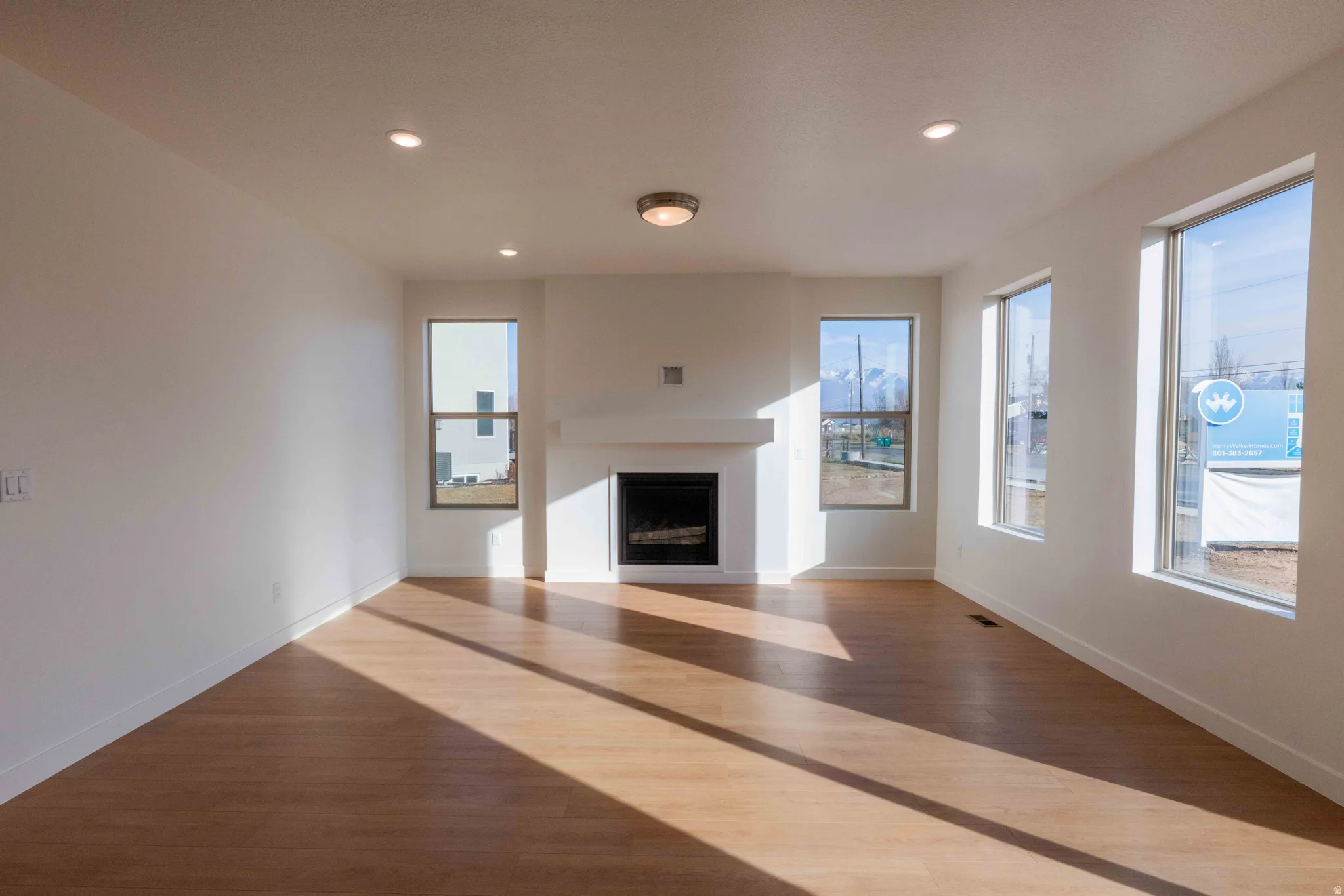 Unfurnished living room featuring wood finished floors, a fireplace, and recessed lighting