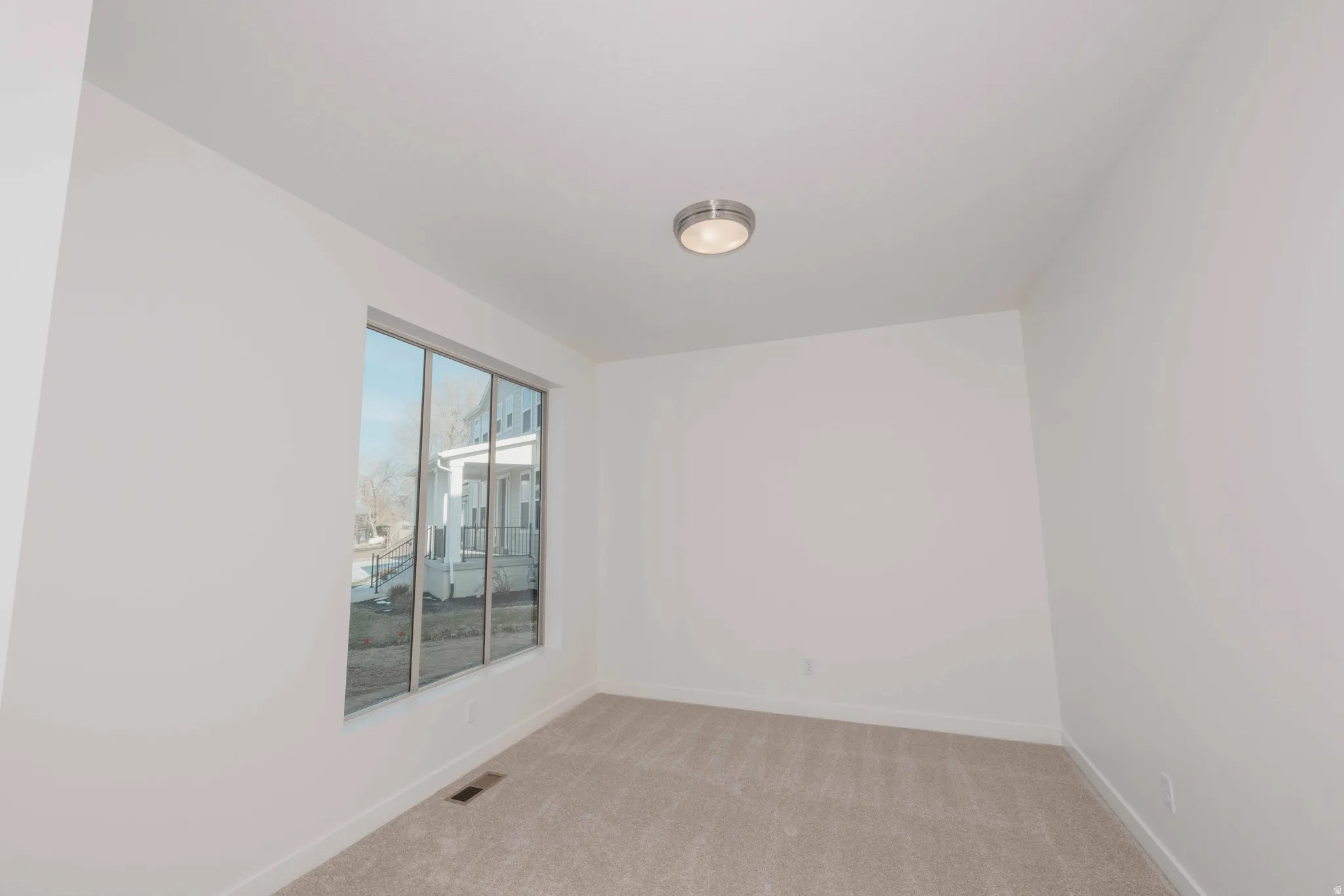 Unfurnished room with light colored carpet and baseboards