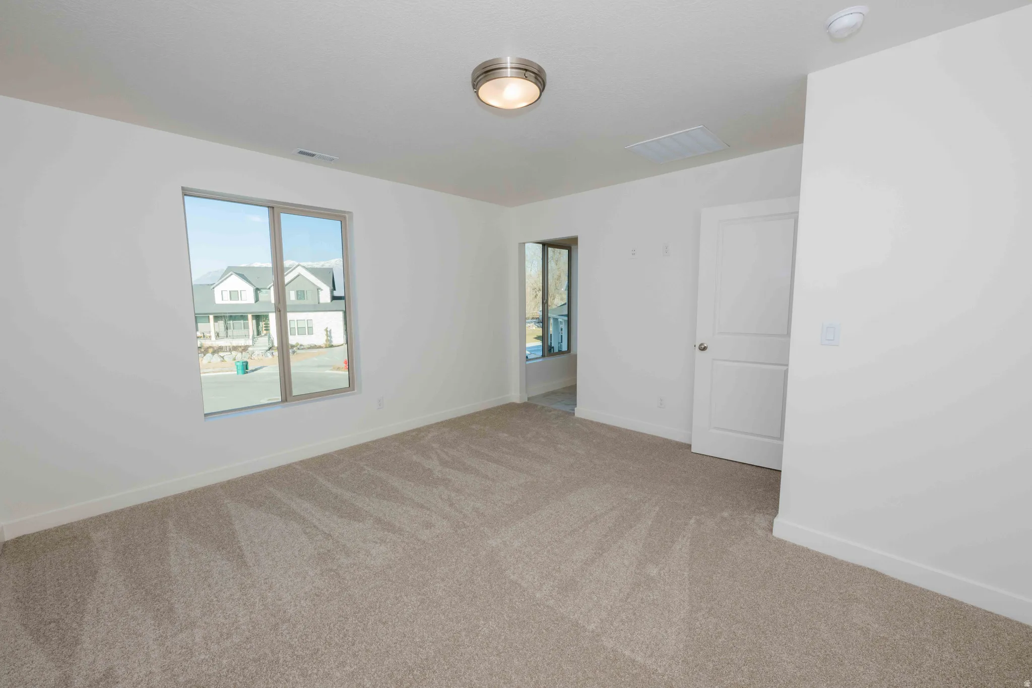 Spare room with light colored carpet and baseboards