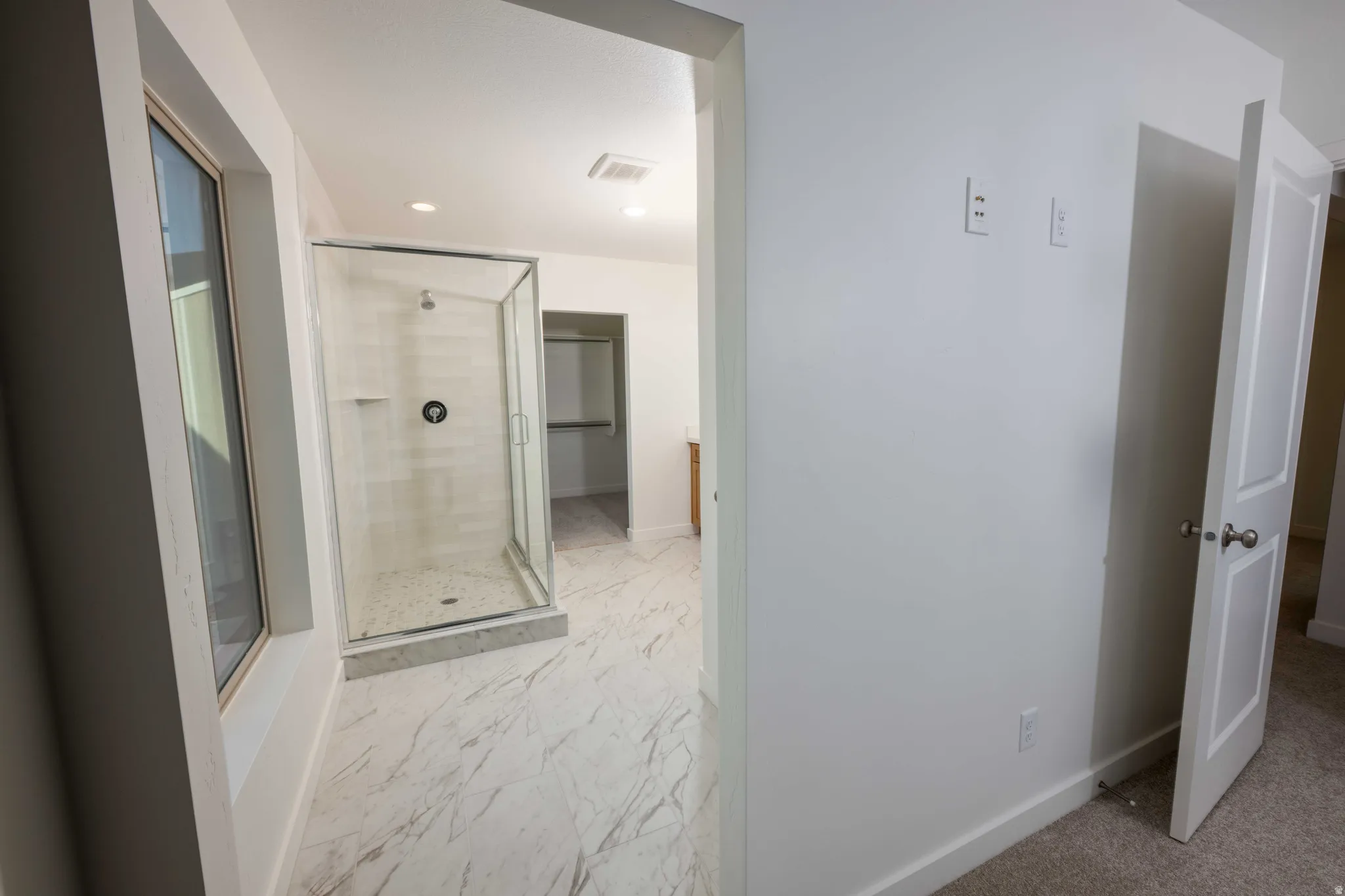 Full bath featuring a shower stall, light marble finish flooring, recessed lighting, and vanity