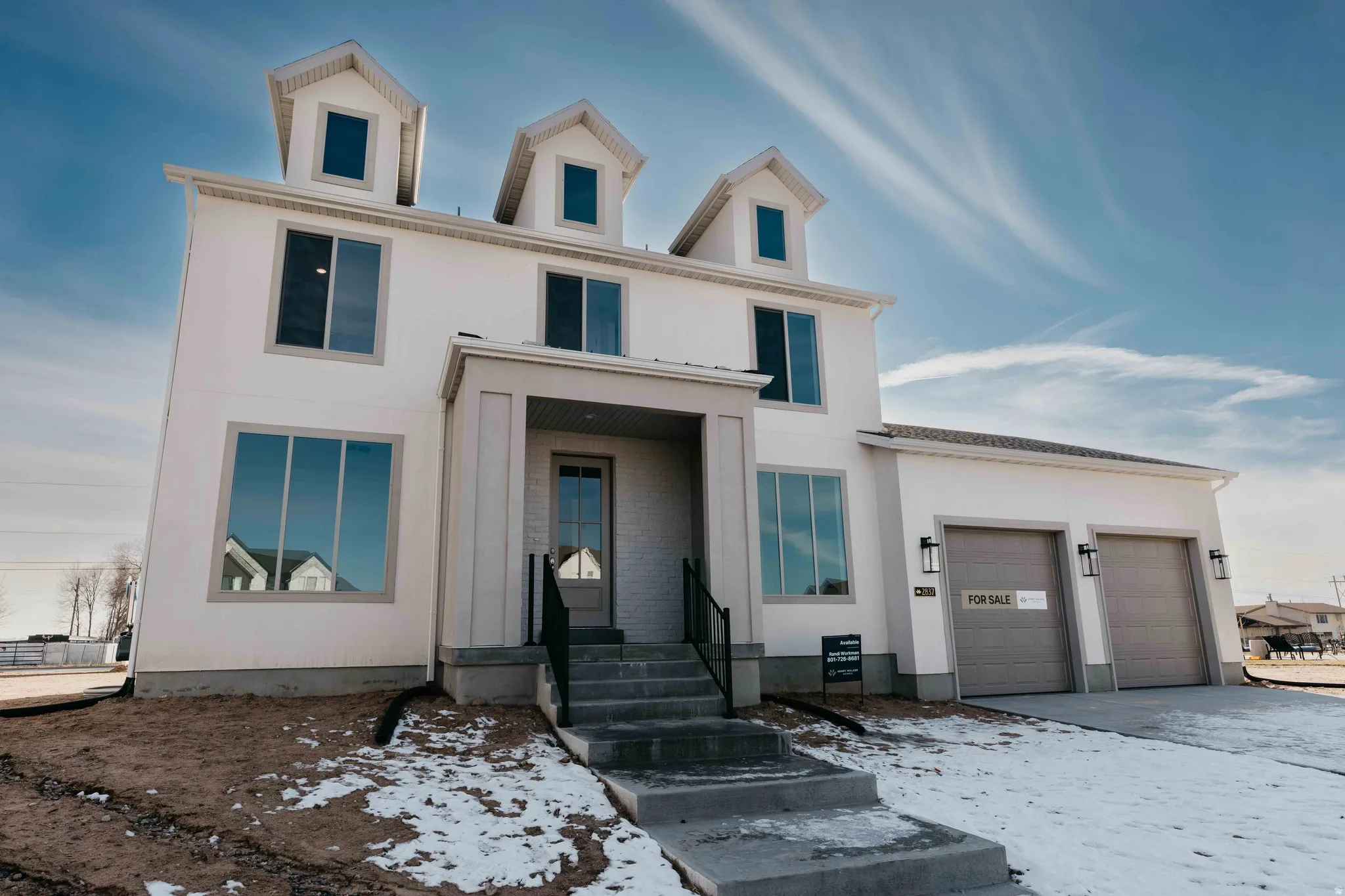 View of front of home with an attached garage and stucco siding