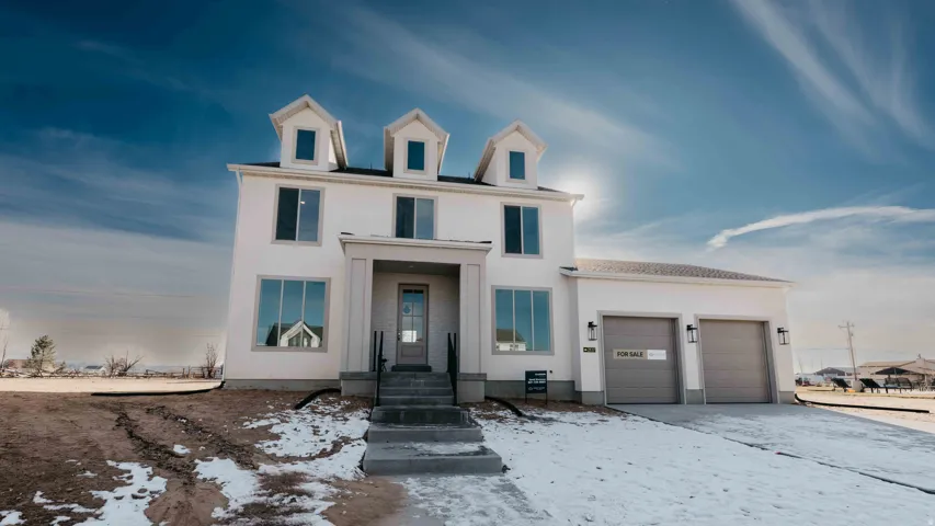 View of front facade with a garage, stucco siding, and driveway