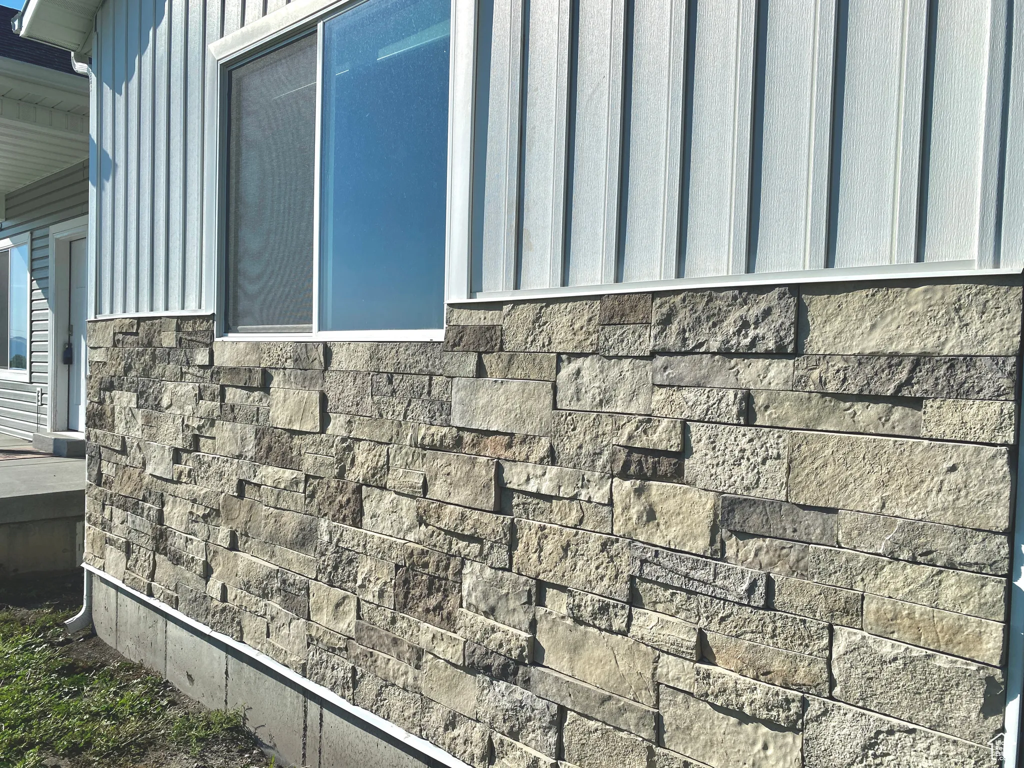 Exterior view of board and batten siding and stone siding