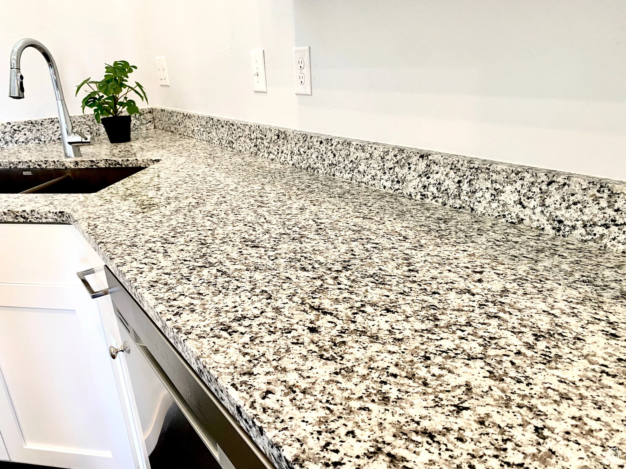 Detailed view of white cabinets and granite stone counters throughout the home.