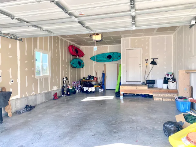 Garage featuring a garage door opener and tandem 3rd bay.