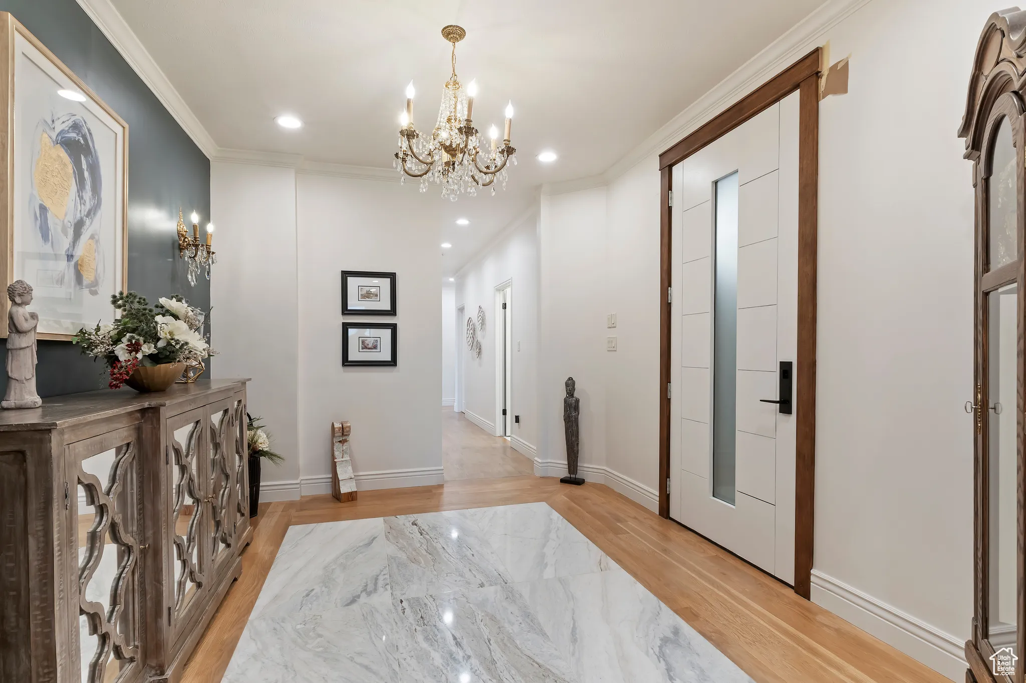 Hallway featuring crown molding, light wood-type flooring, recessed lighting, and a chandelier