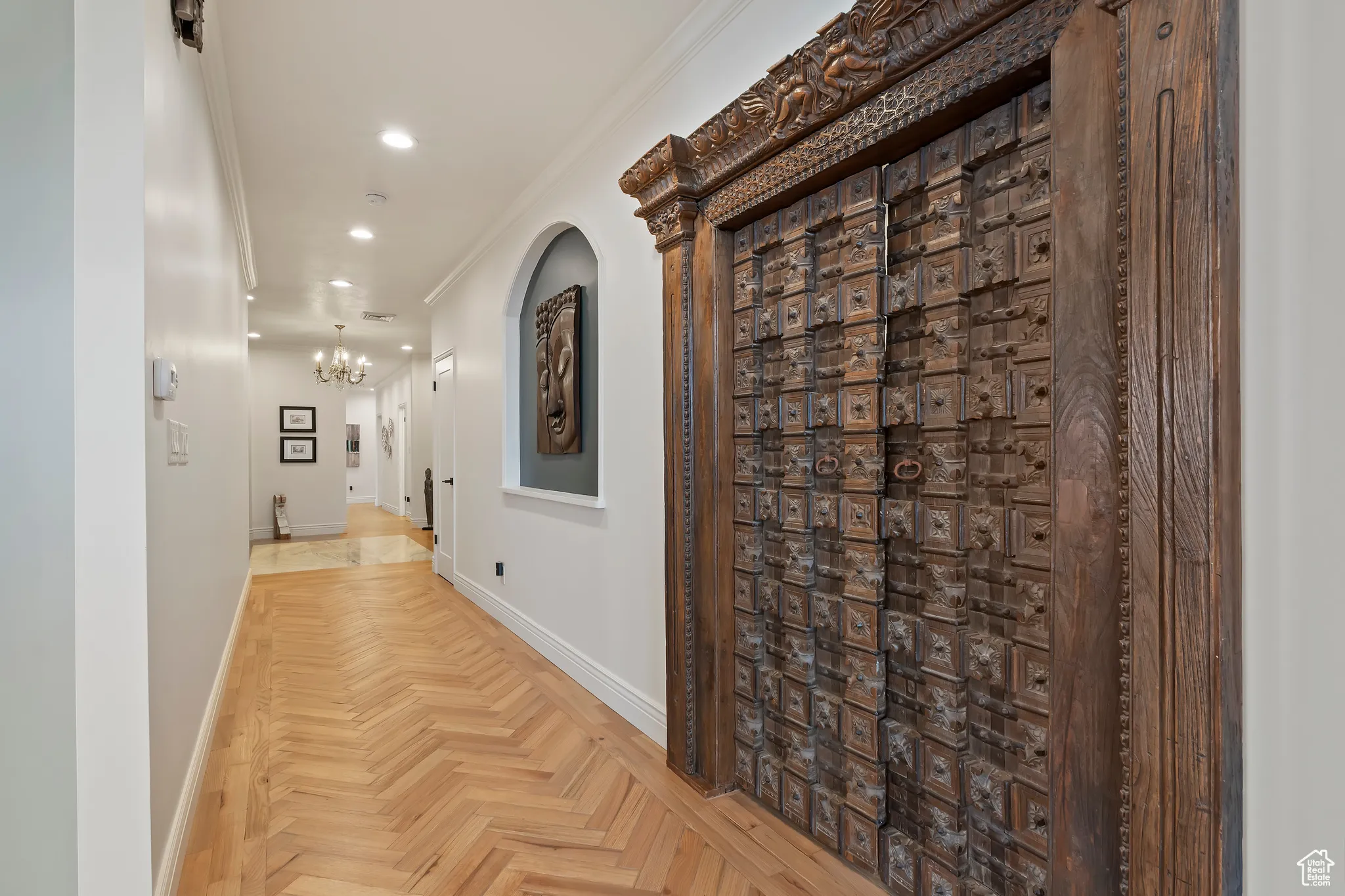 Hall with crown molding, recessed lighting, and a chandelier