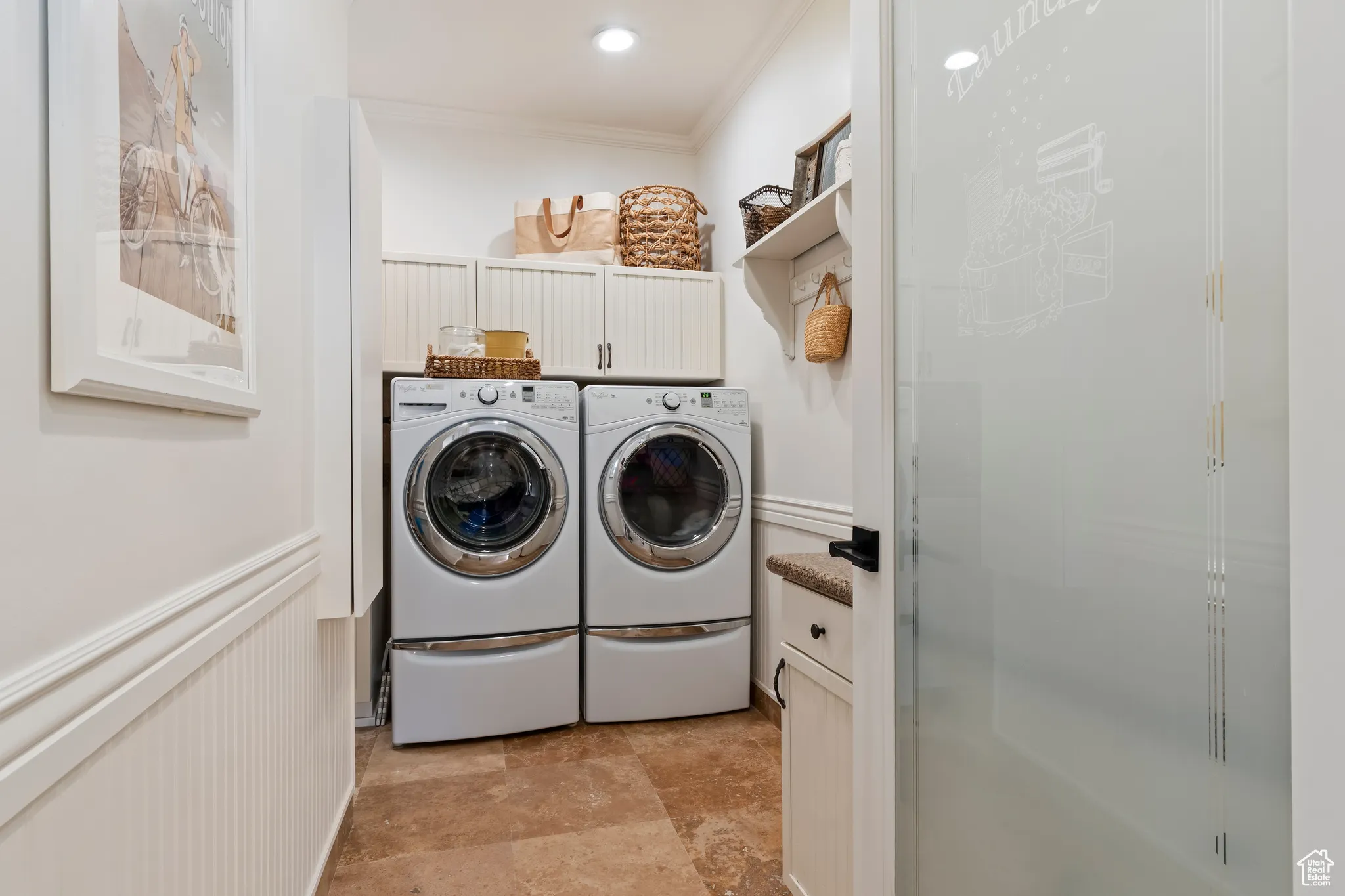 Washroom with washer and dryer, ornamental molding, a wainscoted wall, and cabinet space