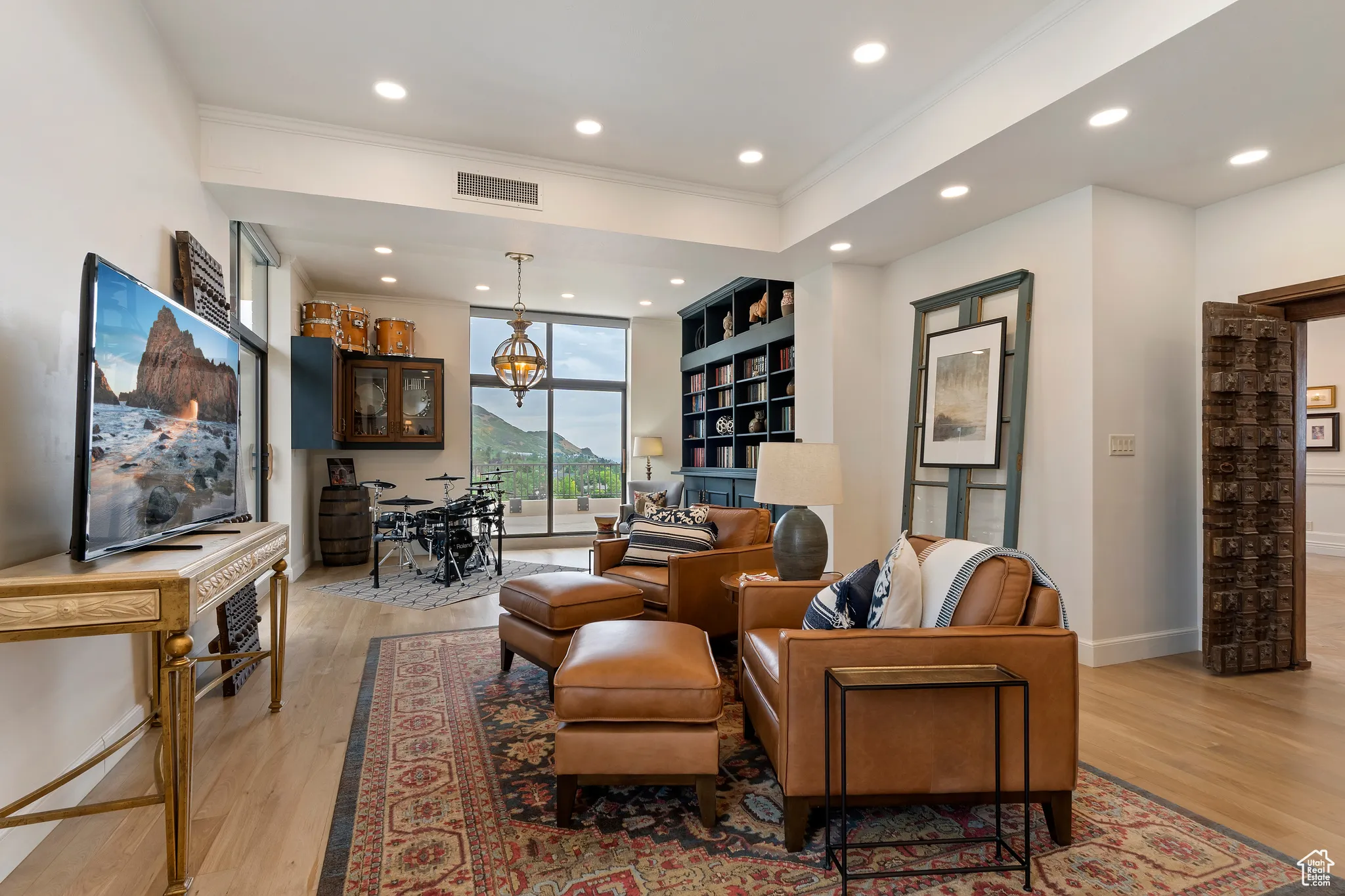 Living area featuring light wood finished floors, recessed lighting, and crown molding