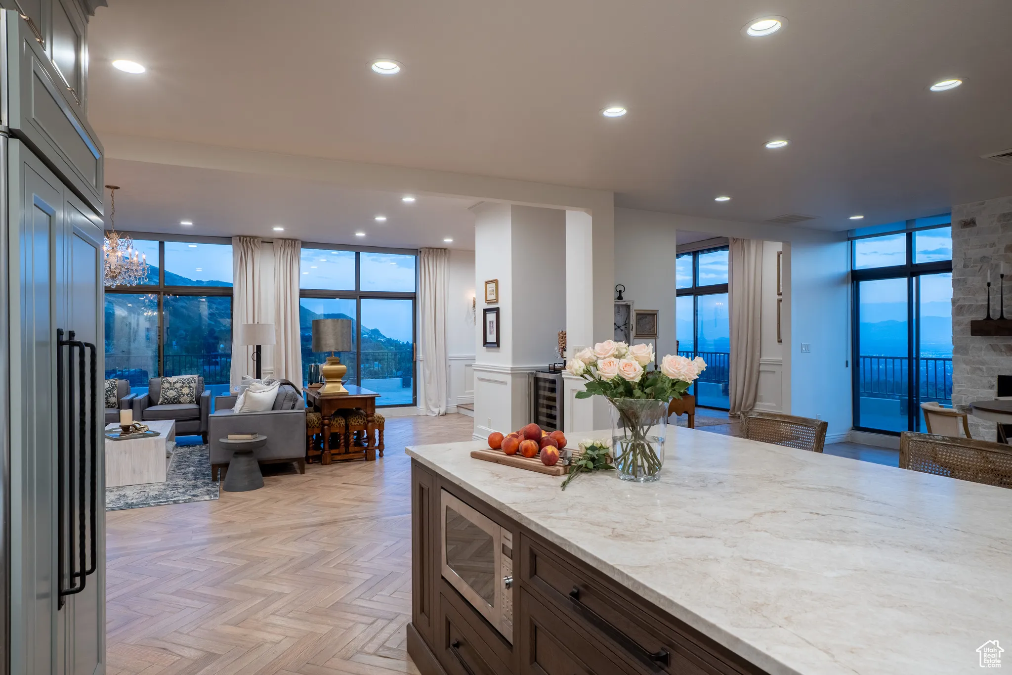 Kitchen featuring open floor plan, a wall of windows, a mountain view, light stone counters, and recessed lighting