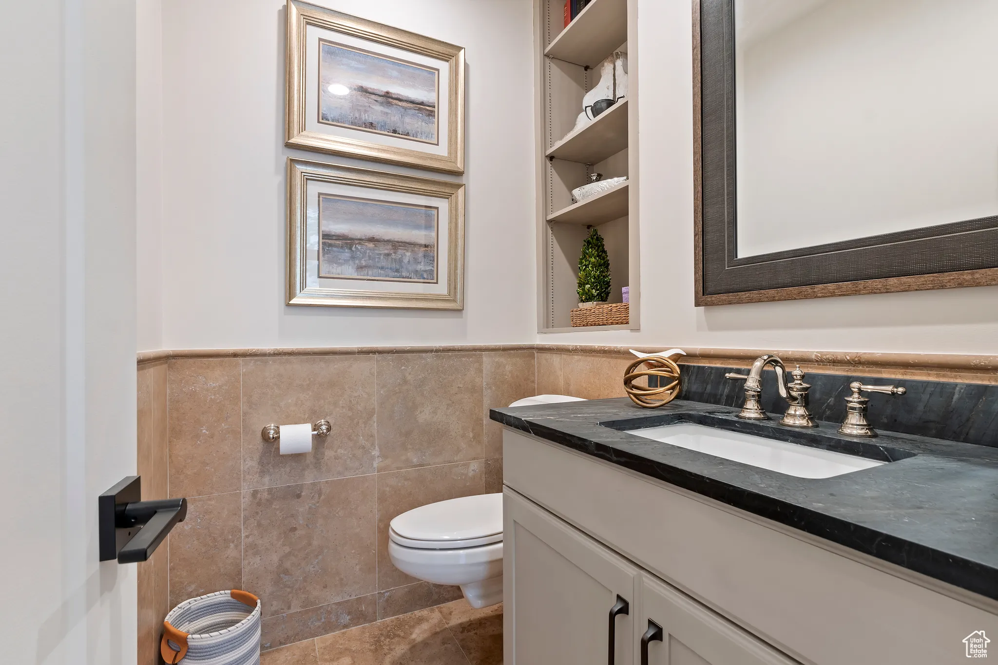 Bathroom with vanity, tile walls, and a wainscoted wall