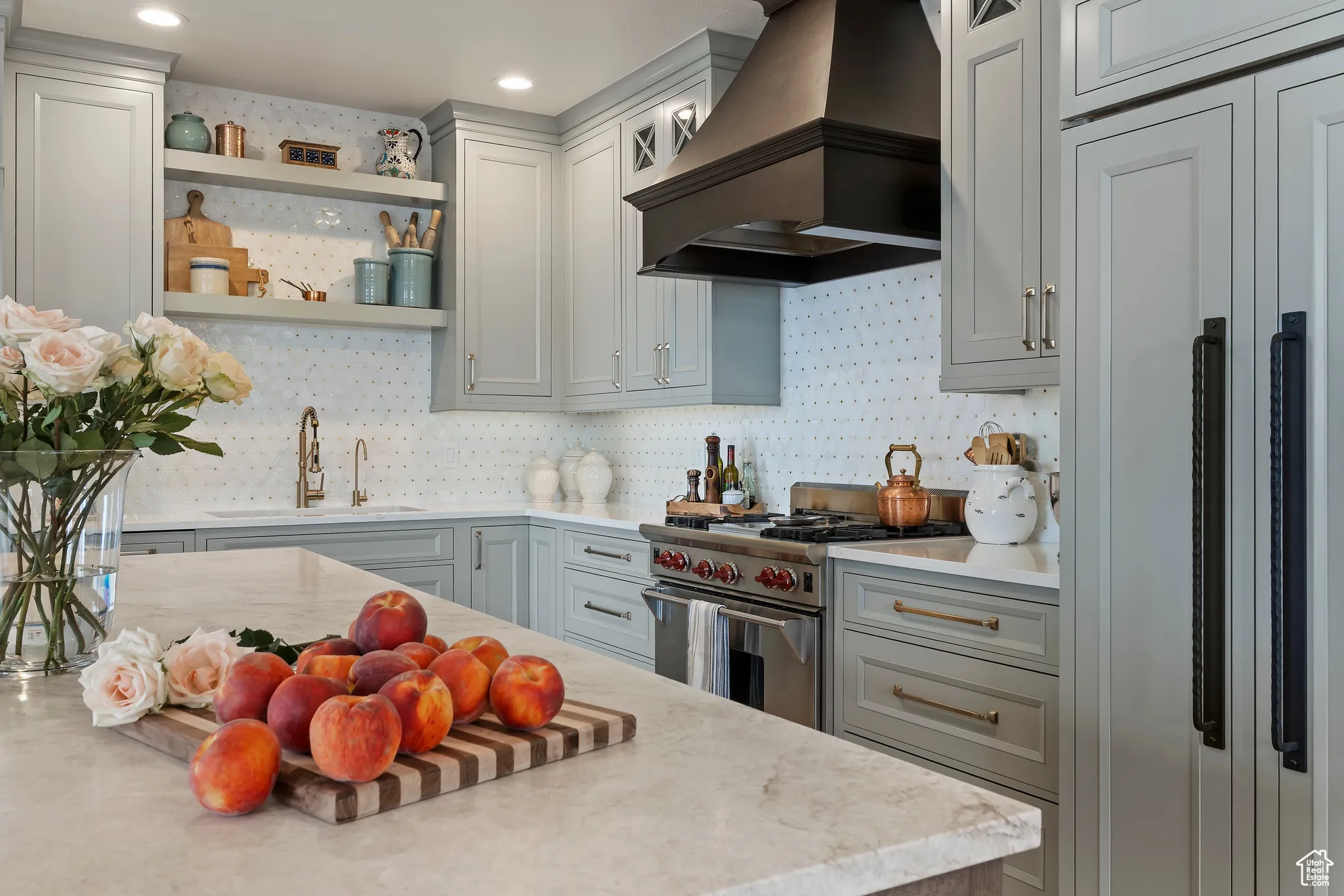 Kitchen featuring premium range hood, premium appliances, open shelves, glass insert cabinets, and decorative backsplash