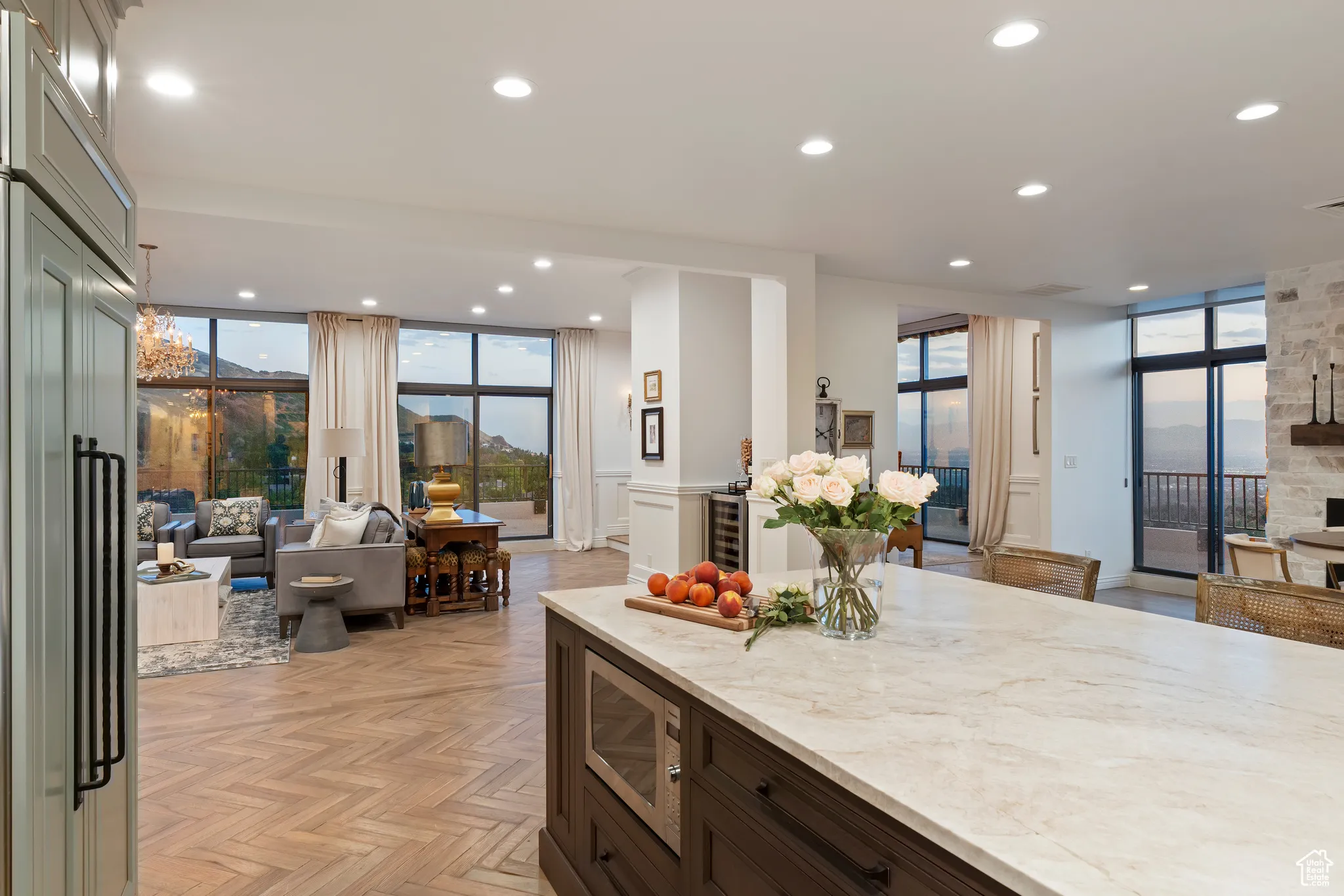 Kitchen featuring open floor plan, floor to ceiling windows, light stone counters, stainless steel microwave, and recessed lighting