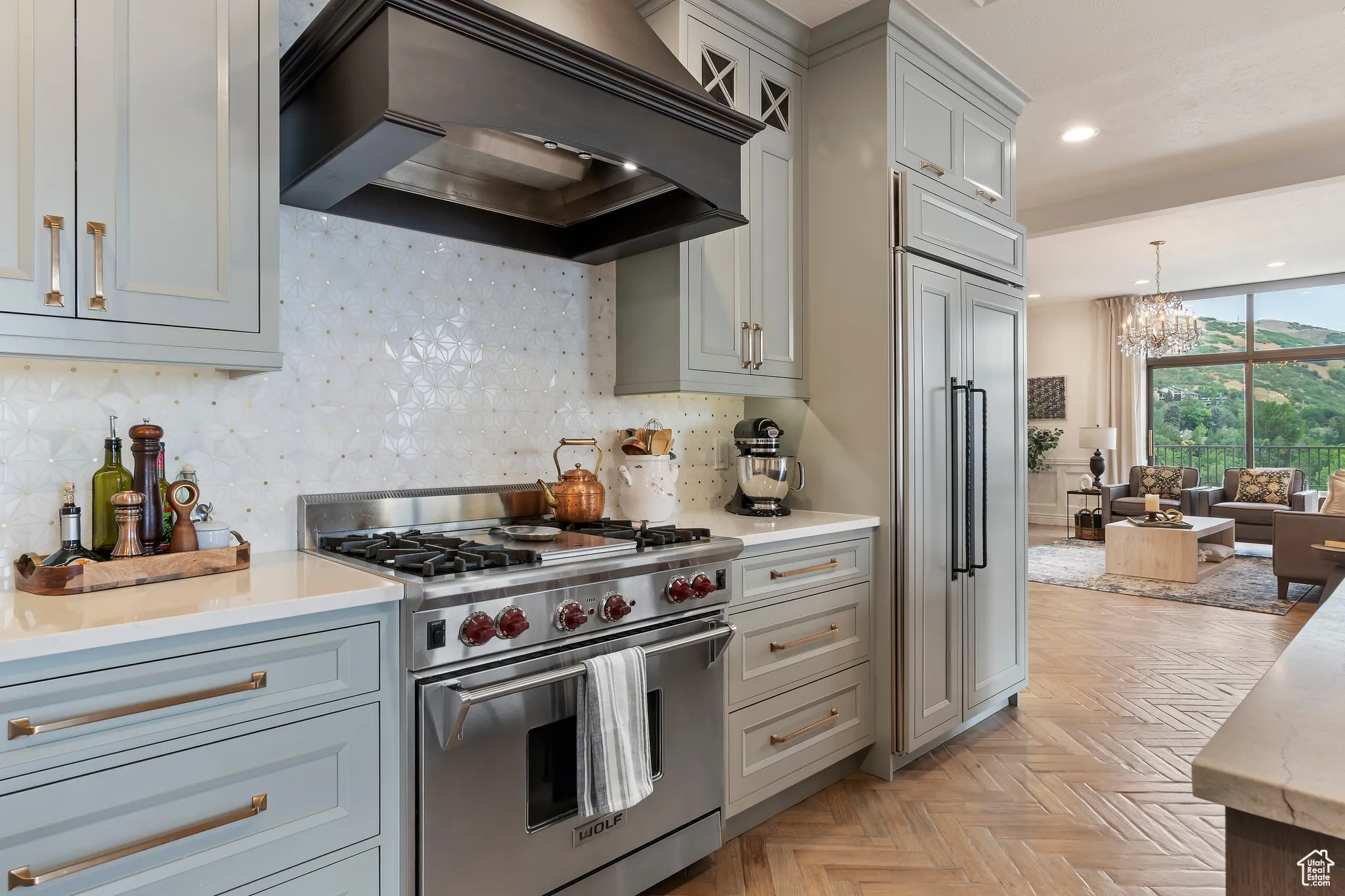 Kitchen featuring high end appliances, custom exhaust hood, decorative backsplash, a chandelier, and recessed lighting