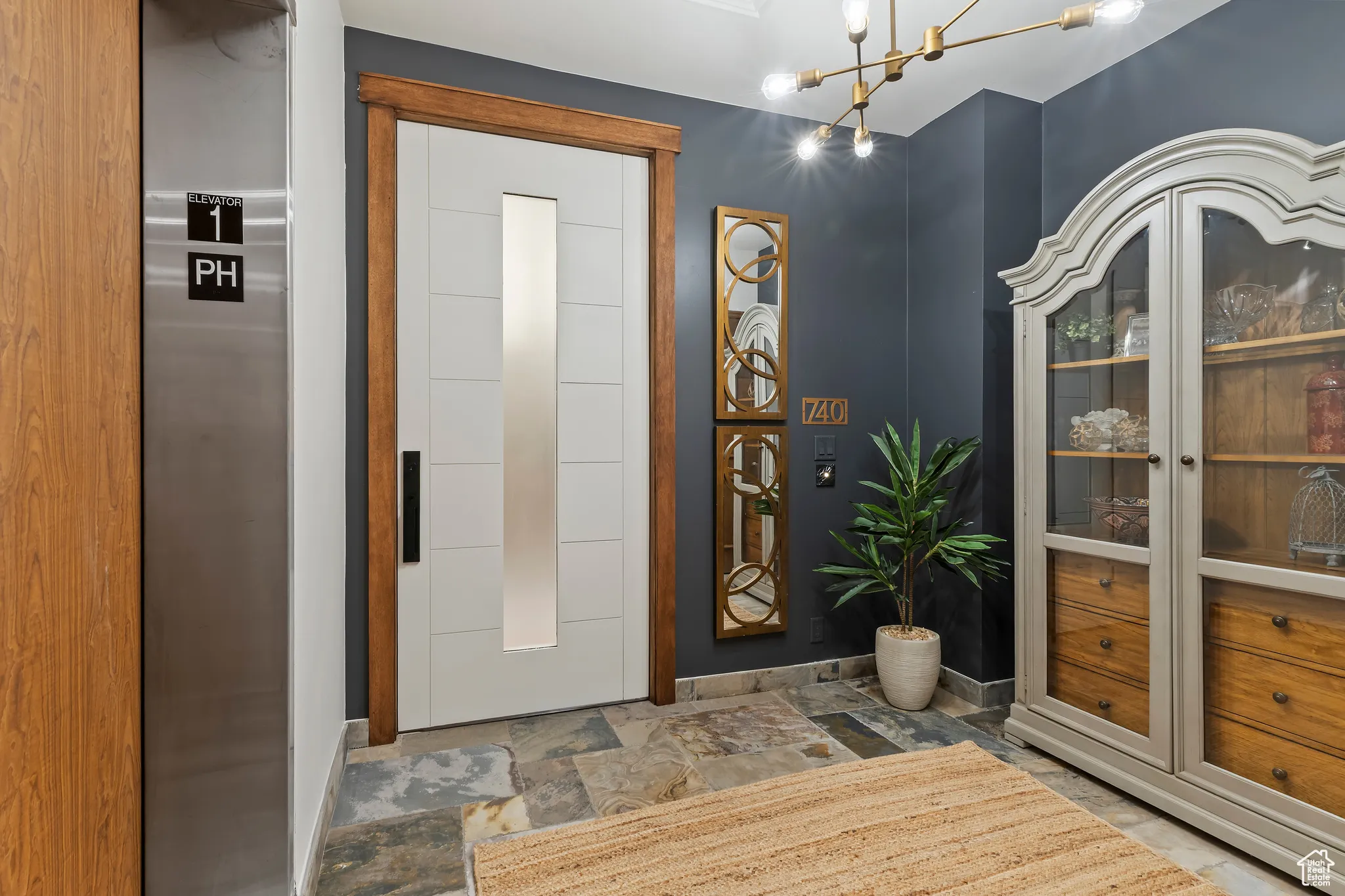 Foyer with a chandelier and stone finish floors