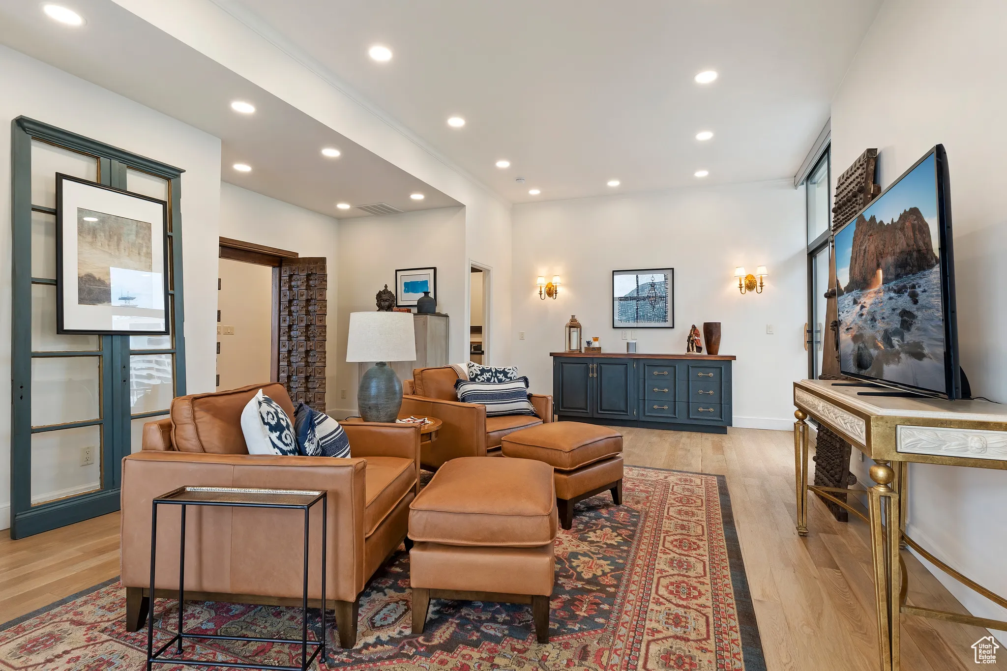 Living area with light wood-style flooring and recessed lighting