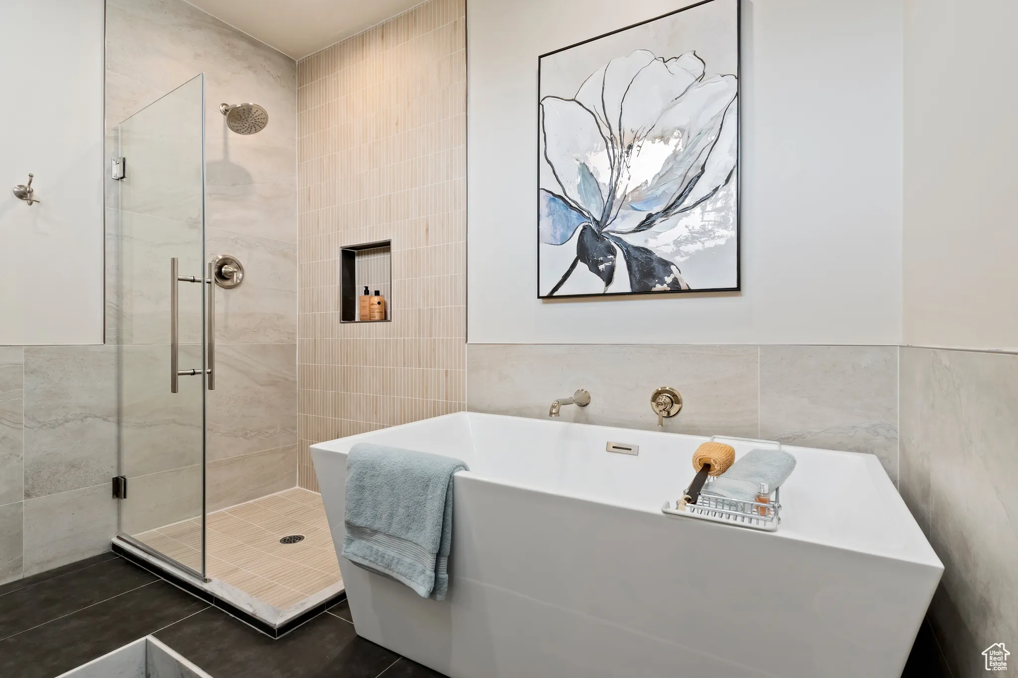 Bathroom with tile walls, a freestanding bath, and a stall shower