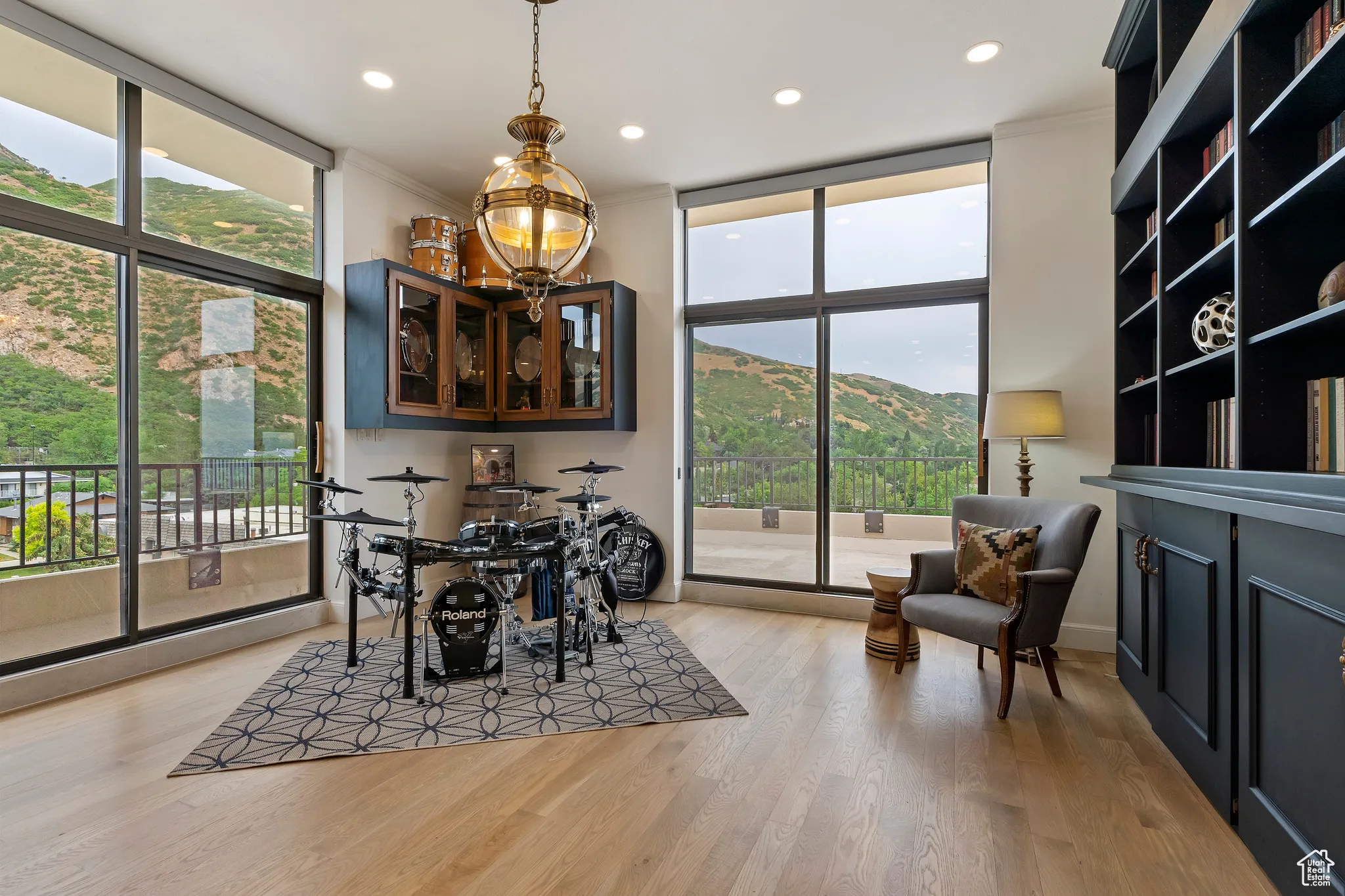 Dining space with a wall of windows, light wood-style flooring, a mountain view, recessed lighting, and a chandelier