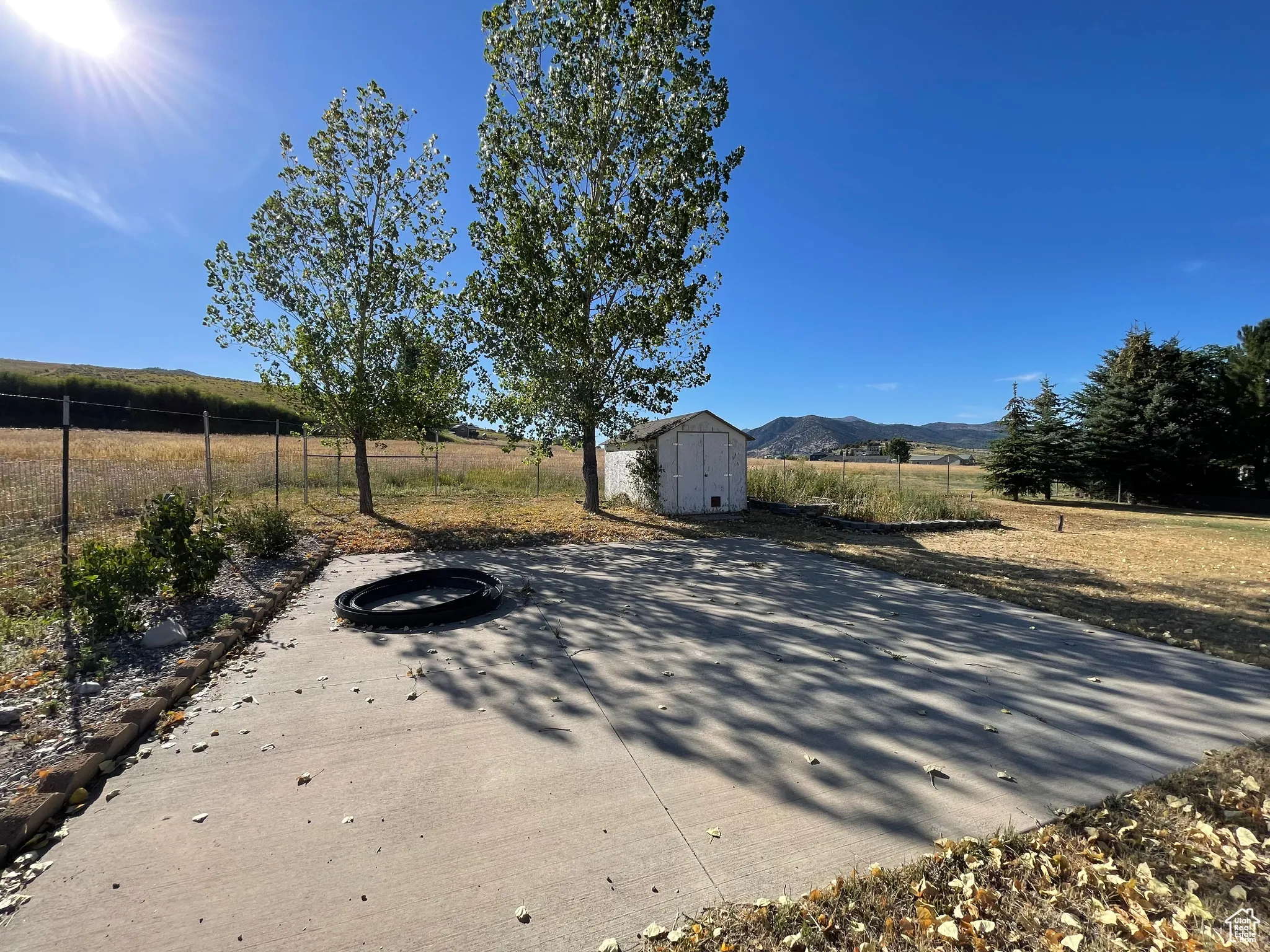 View of patio with a storage unit, a mountain view, and a view of countryside