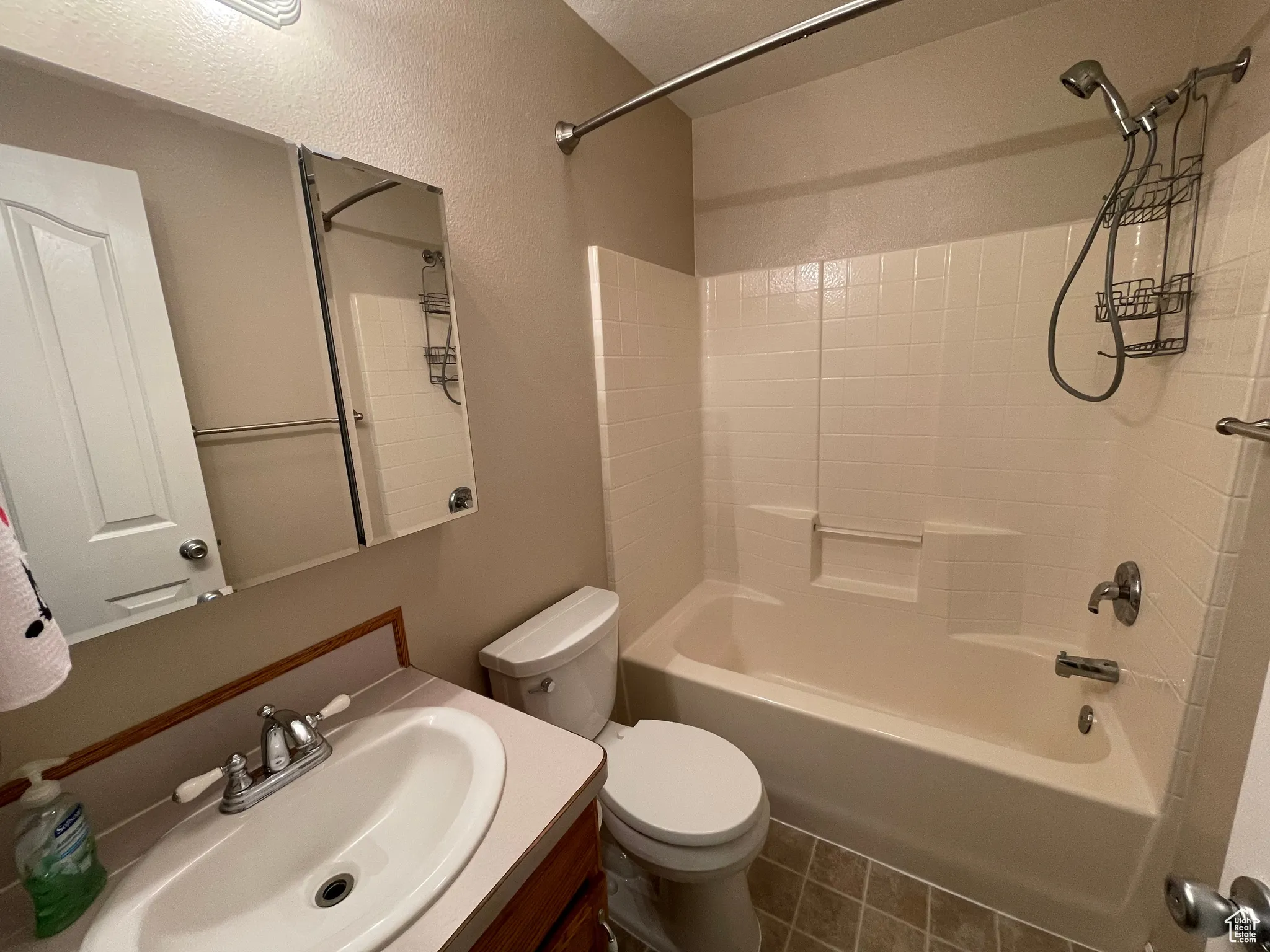 Full bathroom featuring washtub / shower combination, vanity, and tile patterned flooring