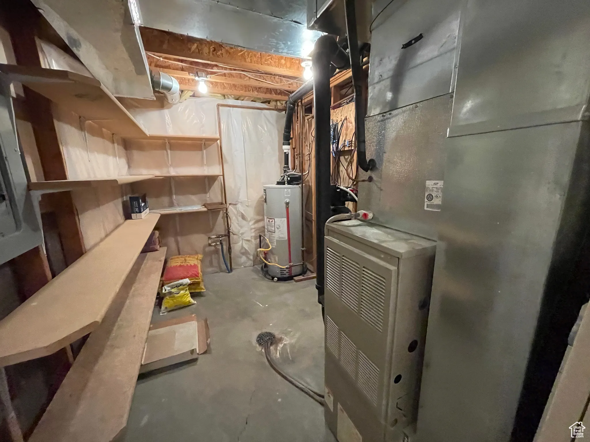 Unfinished below grade area featuring heating unit and gas water heater