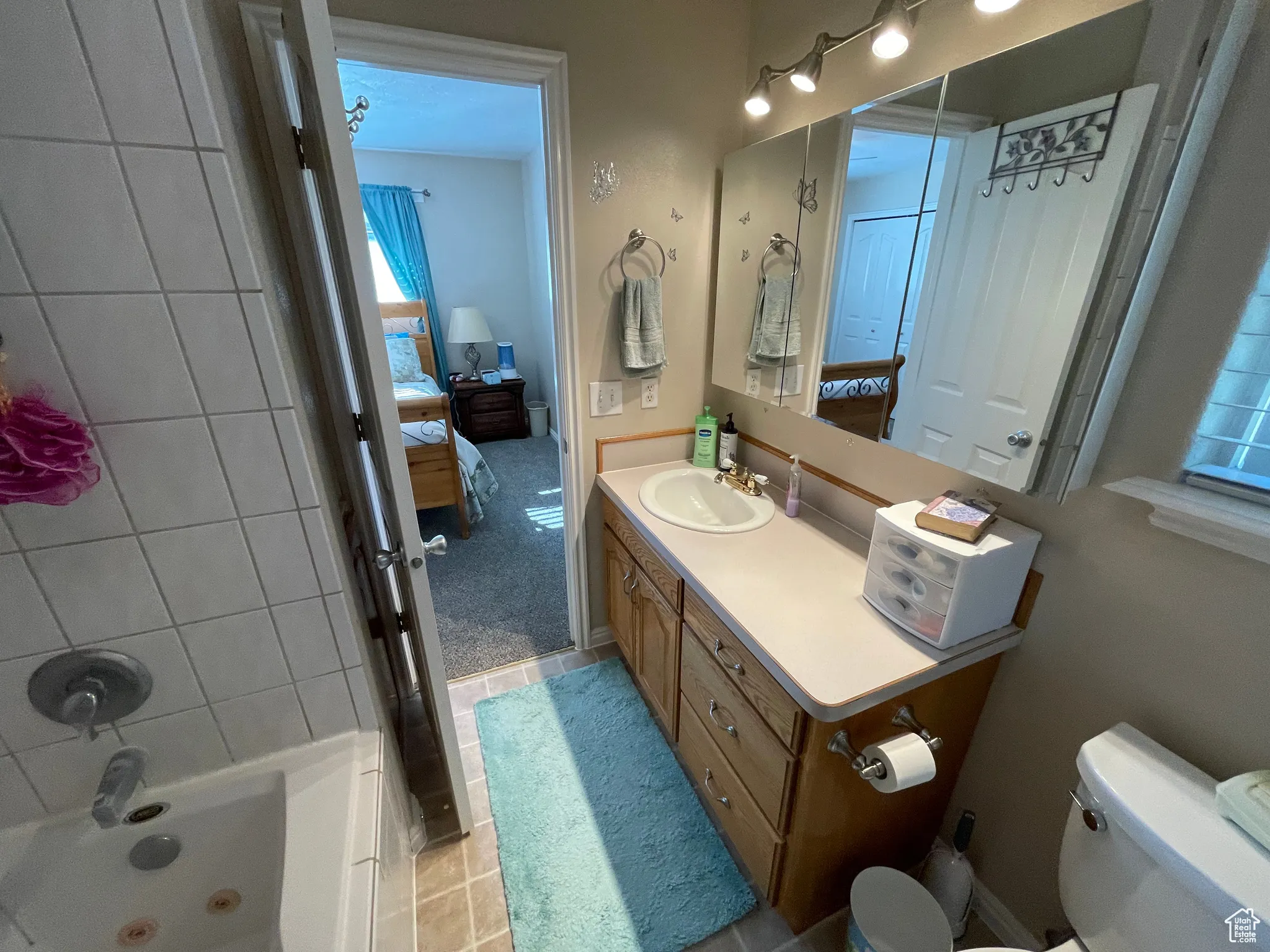 Full bath with ensuite bath, vanity, tile patterned flooring, and bathing tub / shower combination
