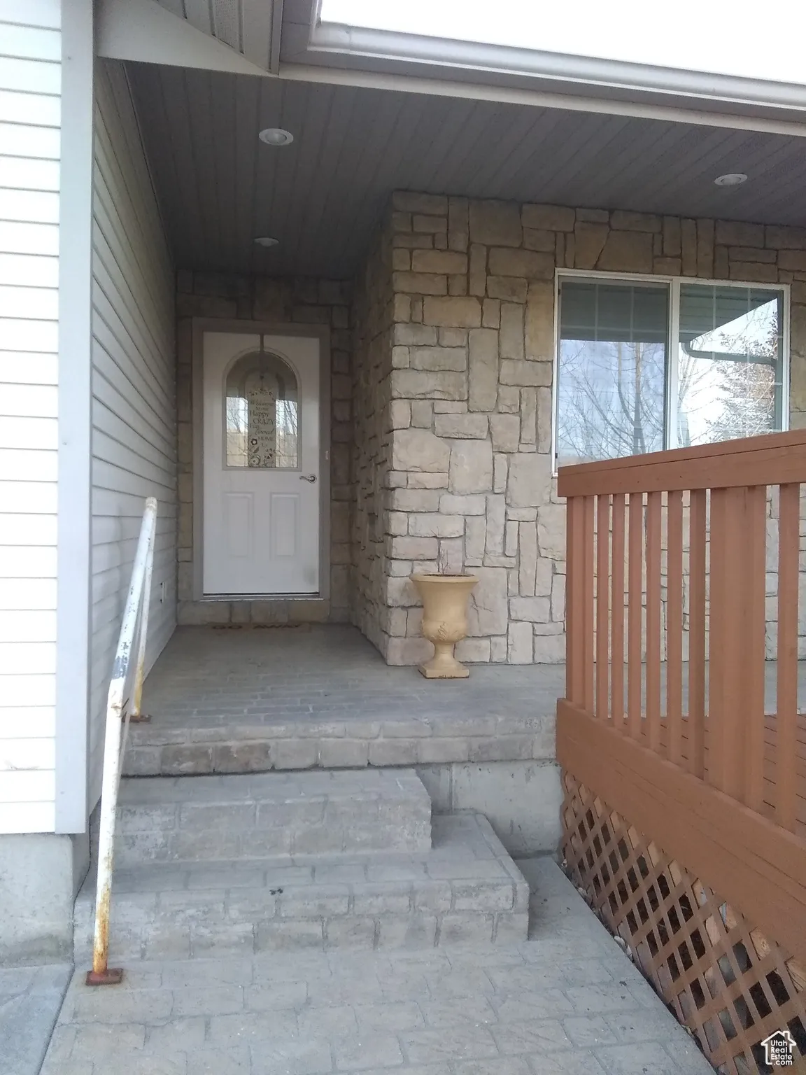 View of exterior entry with a porch and stone siding