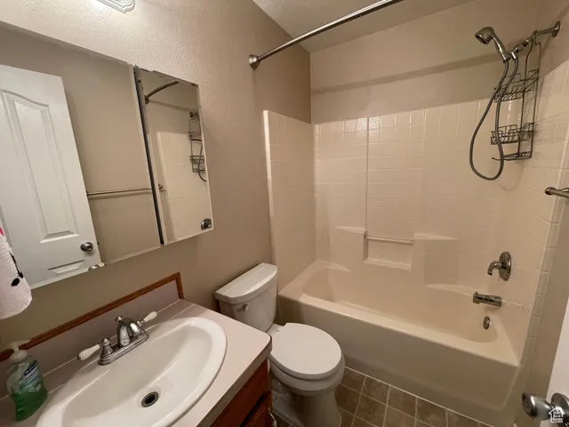 Full bathroom featuring washtub / shower combination, vanity, and tile patterned flooring