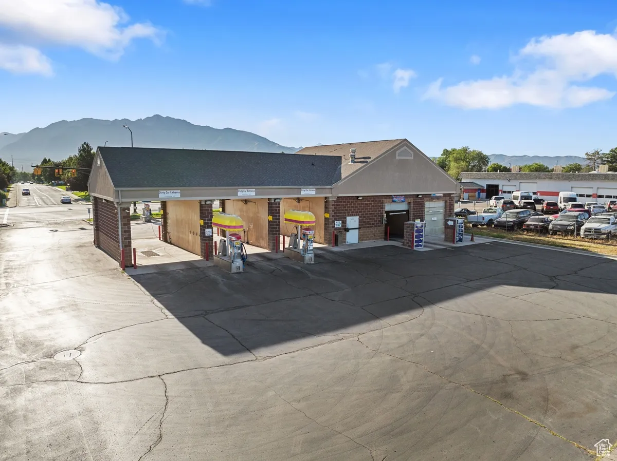 View of front of property with brick siding, a mountain view, and uncovered parking