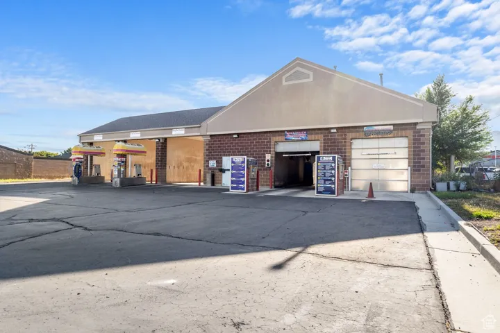 View of front facade with brick siding, concrete driveway, and an attached garage
