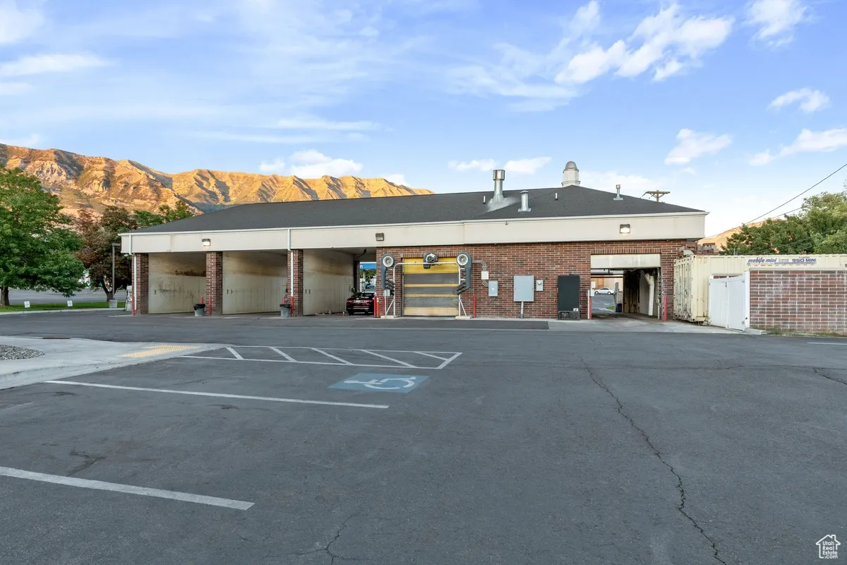 View of property with uncovered parking and a mountain view